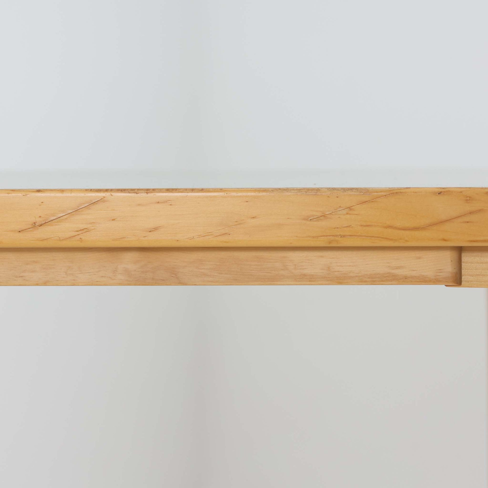 Alvar AaltoがデザインしArtek社より製造されたこちらのダイニングテーブルは、天板に落ち着いたグレートーンのリノリウム、脚部に美しい木肌のバーチ材を用いた北欧モダンデザインの名作で、L字型に曲げられた脚部がアアルトらしい柔らかな造形美を感じさせます。幅120cmの使い勝手のよいサイズ感で、ダイニングやワークスペースにもしっくりと馴染み、天板裏面には脚の付け替え跡が見られ、アアルト製品が多く採用されていたデンマークの公共施設で丁寧に使用されていた個体です。機能美と素材感のバランスに優れた一台です。