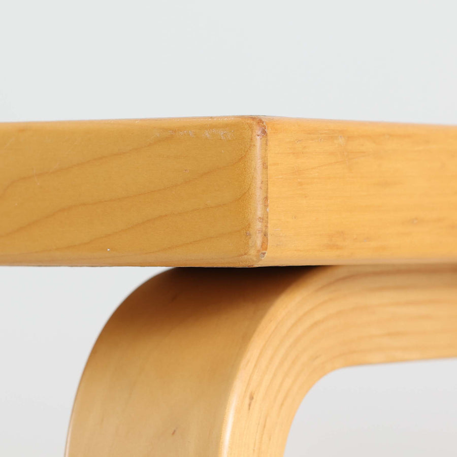 Alvar AaltoがデザインしArtek社より製造されたこちらのダイニングテーブルは、天板に落ち着いたグレートーンのリノリウム、脚部に美しい木肌のバーチ材を用いた北欧モダンデザインの名作で、L字型に曲げられた脚部がアアルトらしい柔らかな造形美を感じさせます。幅120cmの使い勝手のよいサイズ感で、ダイニングやワークスペースにもしっくりと馴染み、機能美と素材感のバランスに優れた一台です。