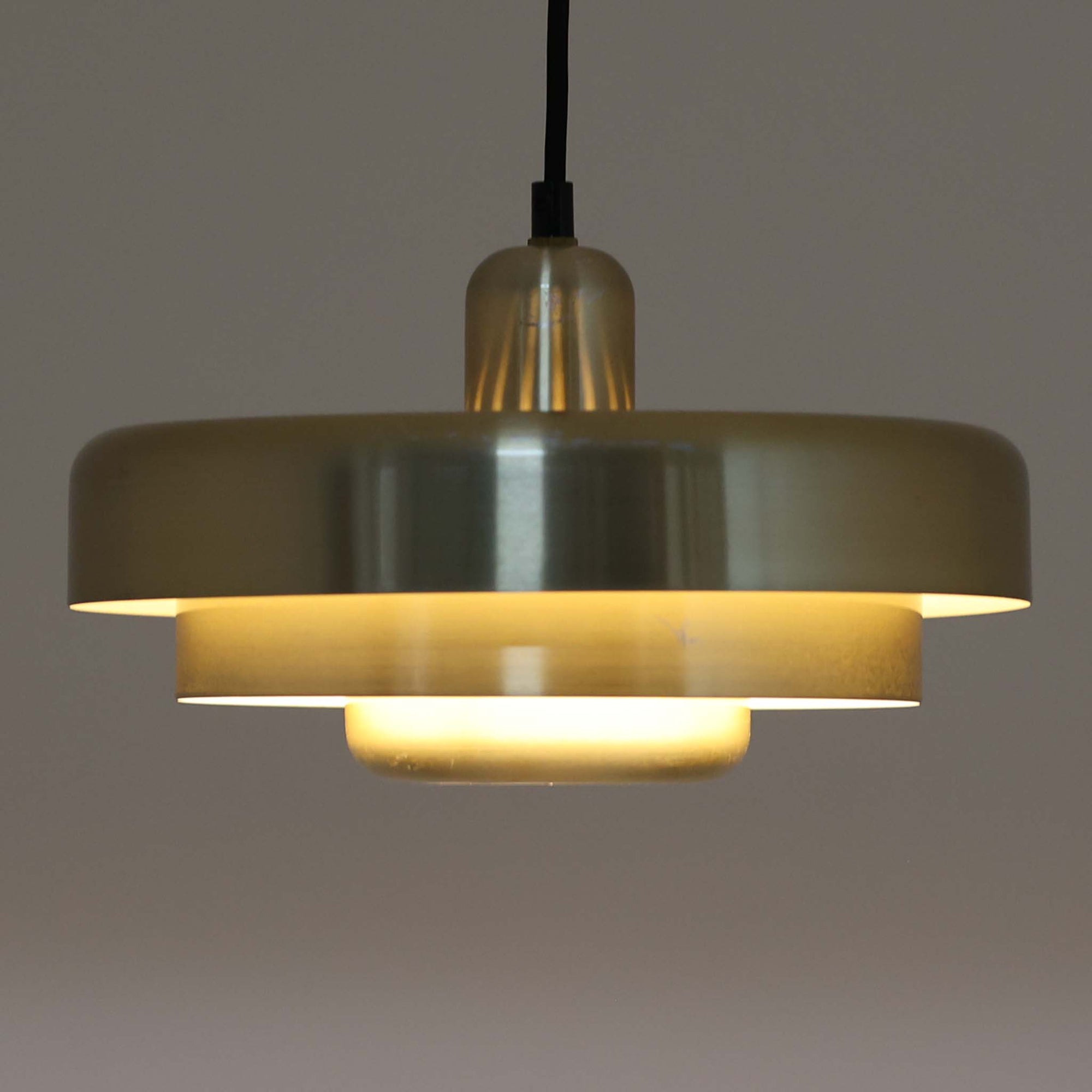 Vitrika社製のペンダントライト「Gogo」です。直径30cmのサイズで、アルミ素材のシェードを段階的に重ねたデザインが特徴的です。光源を巧みに覆い隠しながらも、上下に柔らかく光を広げる構造により、落ち着いた雰囲気を演出します。真鍮のようなゴールド調の質感が高級感を加え、ビンテージならではの風合いと存在感を楽しめます。コンパクトながらも印象的なデザインで、ダイニングや玄関、書斎など多様なシーンに適した照明です。