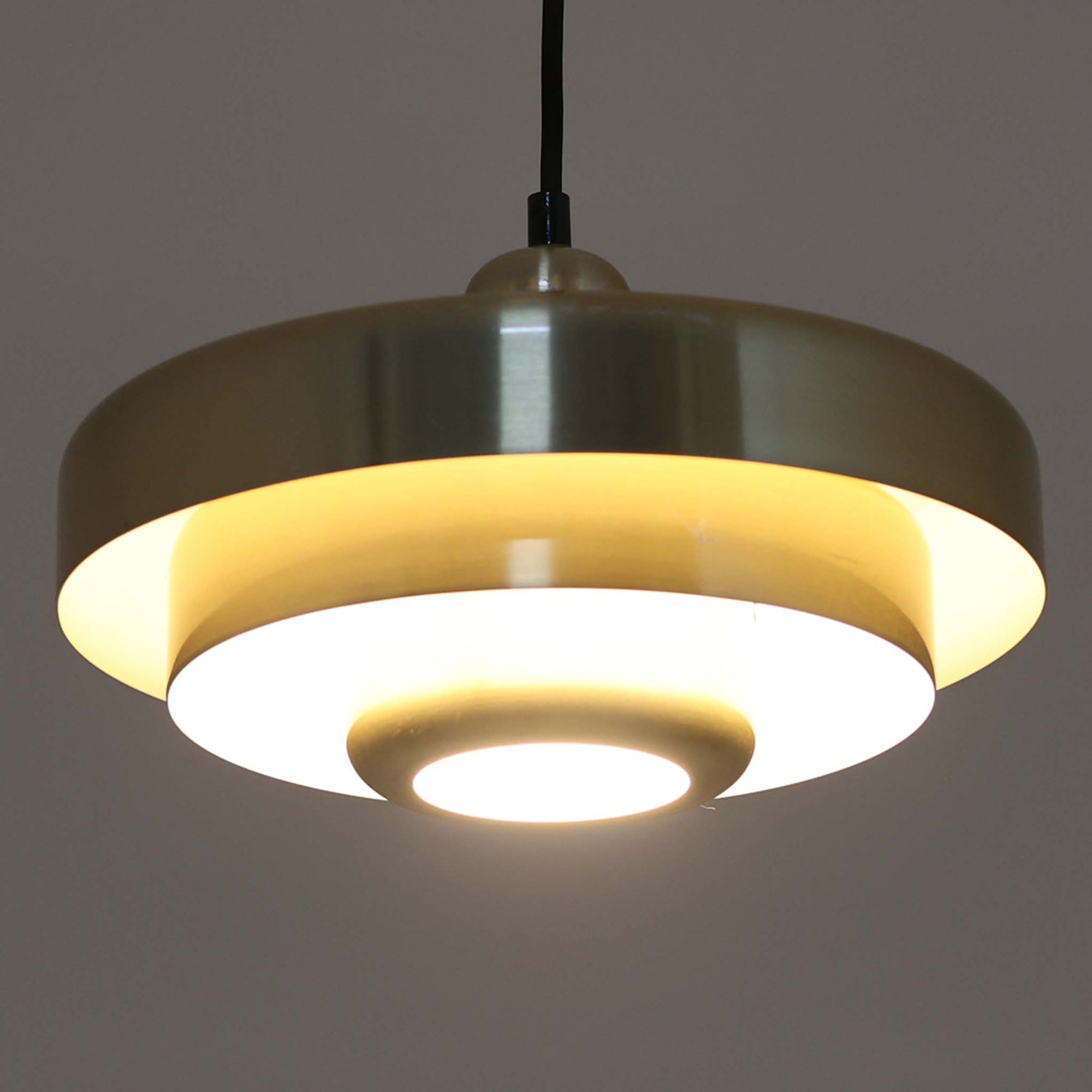 Vitrika社製のペンダントライト「Gogo」です。直径30cmのサイズで、アルミ素材のシェードを段階的に重ねたデザインが特徴的です。光源を巧みに覆い隠しながらも、上下に柔らかく光を広げる構造により、落ち着いた雰囲気を演出します。真鍮のようなゴールド調の質感が高級感を加え、ビンテージならではの風合いと存在感を楽しめます。コンパクトながらも印象的なデザインで、ダイニングや玄関、書斎など多様なシーンに適した照明です。