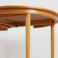 デンマークの老舗家具メーカー、Farstrup Mobler（ファストラップ・モブラー）による円形エクステンションダイニングテーブルです。オーク材の優しい色合いと美しい木目が際立ち、北欧家具らしい明るく軽やかな雰囲気を演出します。円形の天板は互いの距離が自然と近づき、家族や友人との会話が弾む柔らかな空間を生み出します。中央の拡張板を取り付けることで人数や用途に応じてサイズ調整が可能で、普段使いにも来客時にも活躍。テーパー脚のバランスが美しく、シンプルながらも洗練されたデザインが魅力です。温もりある素材感と丁寧な仕上げが、日常の食卓を心地よい時間へと導いてくれます。