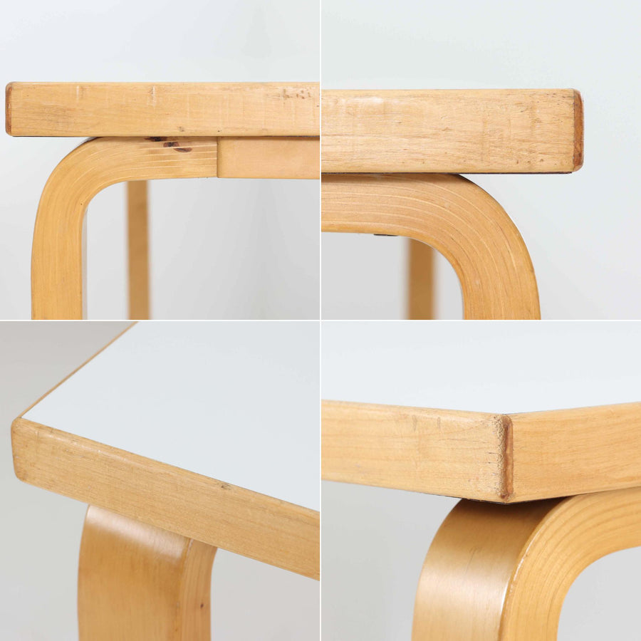 Alvar AaltoがデザインしArtek社より製造されたこちらのダイニングテーブルは、フィンランドモダニズムを象徴する一本。バーチ材の脚部に柔らかくカーブを描くLレッグ構造が取り入れられ、軽やかでありながらも高い強度を実現しています。天板は実用性に優れたホワイトラミネート仕上げで、幅150cmのゆとりあるサイズは家族での食卓やワークスペースにも最適です。機能美と普遍的な美しさを兼ね備えた、北欧ビンテージらしい逸品です。