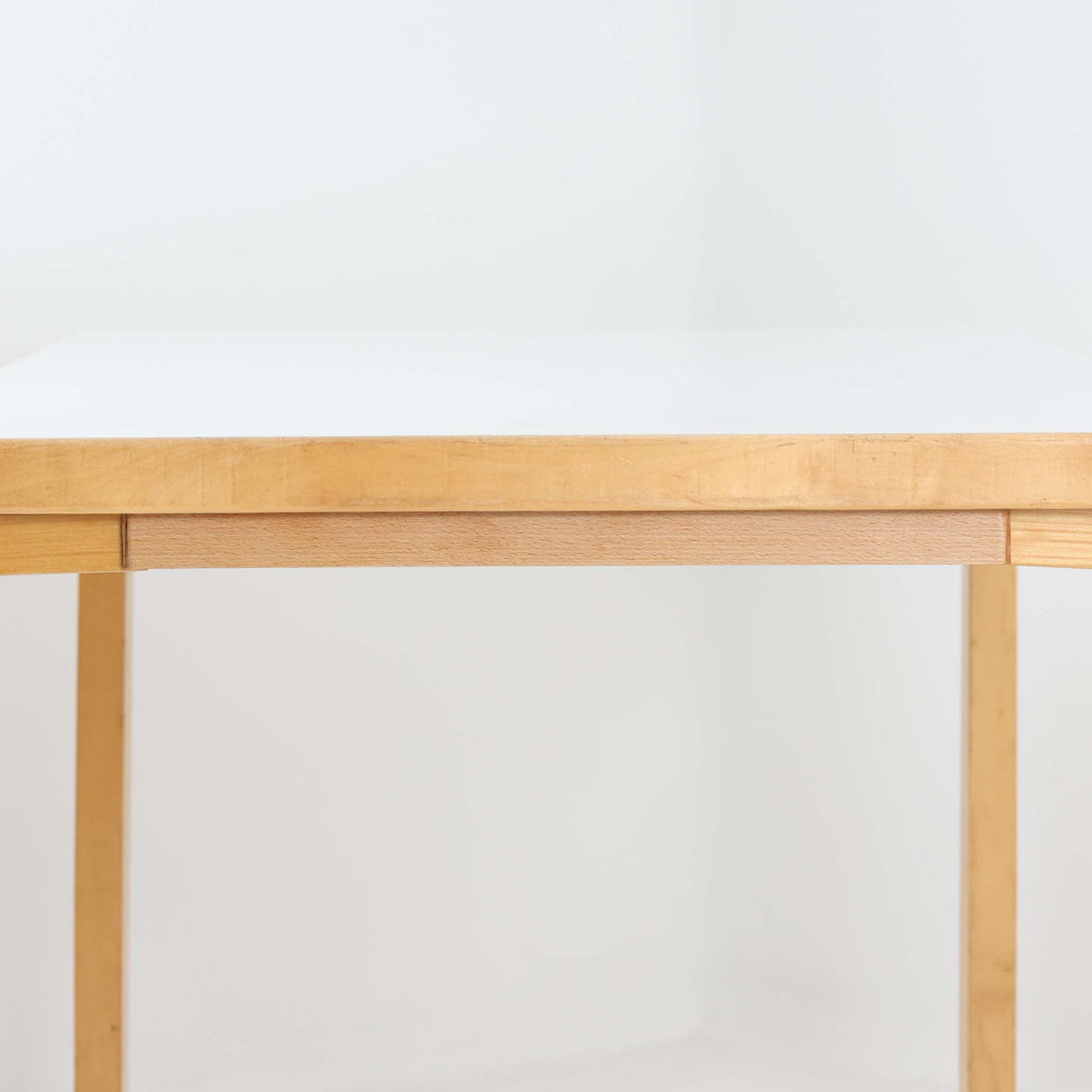 Alvar AaltoがデザインしArtek社より製造されたこちらのダイニングテーブルは、フィンランドモダニズムを象徴する一本。バーチ材の脚部に柔らかくカーブを描くLレッグ構造が取り入れられ、軽やかでありながらも高い強度を実現しています。天板は実用性に優れたホワイトラミネート仕上げで、幅150cmのゆとりあるサイズは家族での食卓やワークスペースにも最適です。機能美と普遍的な美しさを兼ね備えた、北欧ビンテージらしい逸品です。