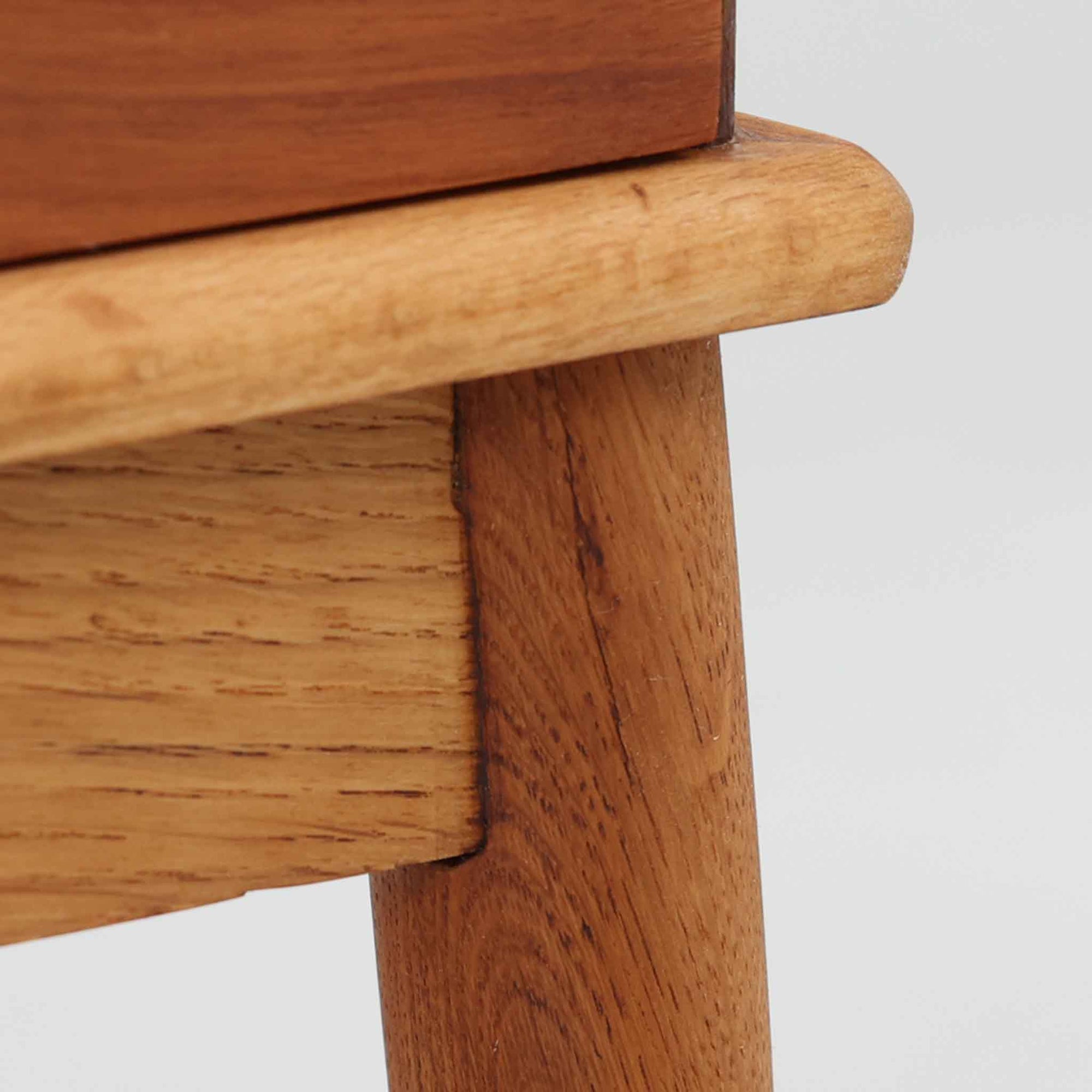 デンマーク製の小ぶりなキャビネットです。チーク材をメインに、オーク材やビーチ材を組み合わせることで、温かみのある色調と軽快な雰囲気を併せ持っています。左側は扉付き収納、右側には3杯の引き出しを備え、実用性とデザイン性を両立。丸みを帯びた取っ手や脚部のテーパーラインが北欧家具らしい柔らかな印象を与えます。幅63cmとコンパクトなサイズで、リビングや寝室、玄関など限られたスペースでも活躍する、ビンテージならではの風合いを持つ一台です。