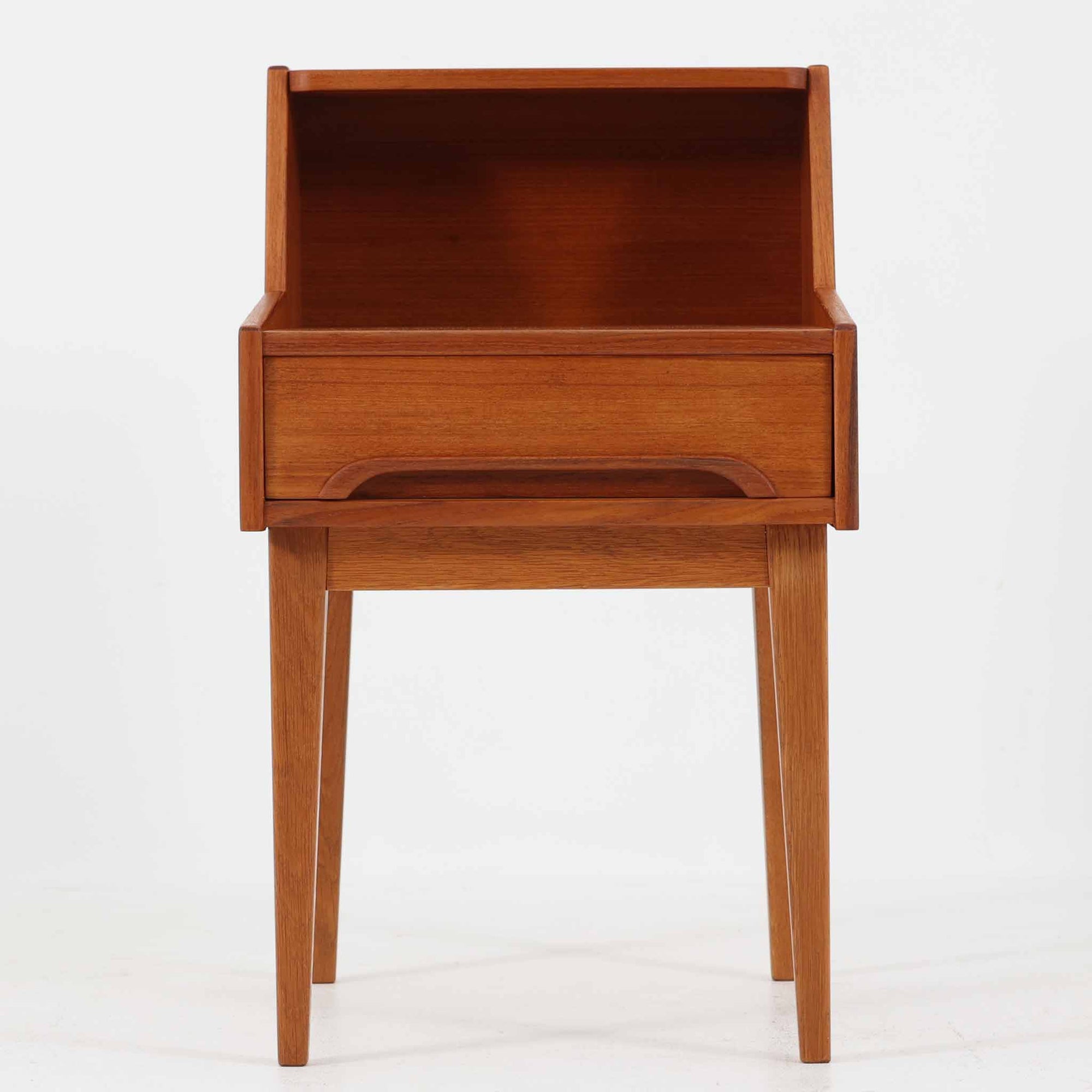 スウェーデン製のこちらのサイドチェストは、チーク材とオーク材を組み合わせた北欧ビンテージ家具で、奥行きのある設計が特徴です。上段は本や小物のディスプレイに、引き出しは日用品の収納に便利で、ナイトテーブルとしての使用にも最適です。直線的で洗練されたフォルムと脚部の無垢材が空間に温もりを添え、年月を経た木肌の風合いが一層の魅力を引き立てます。背面には当時の製造印も残る一点物です。