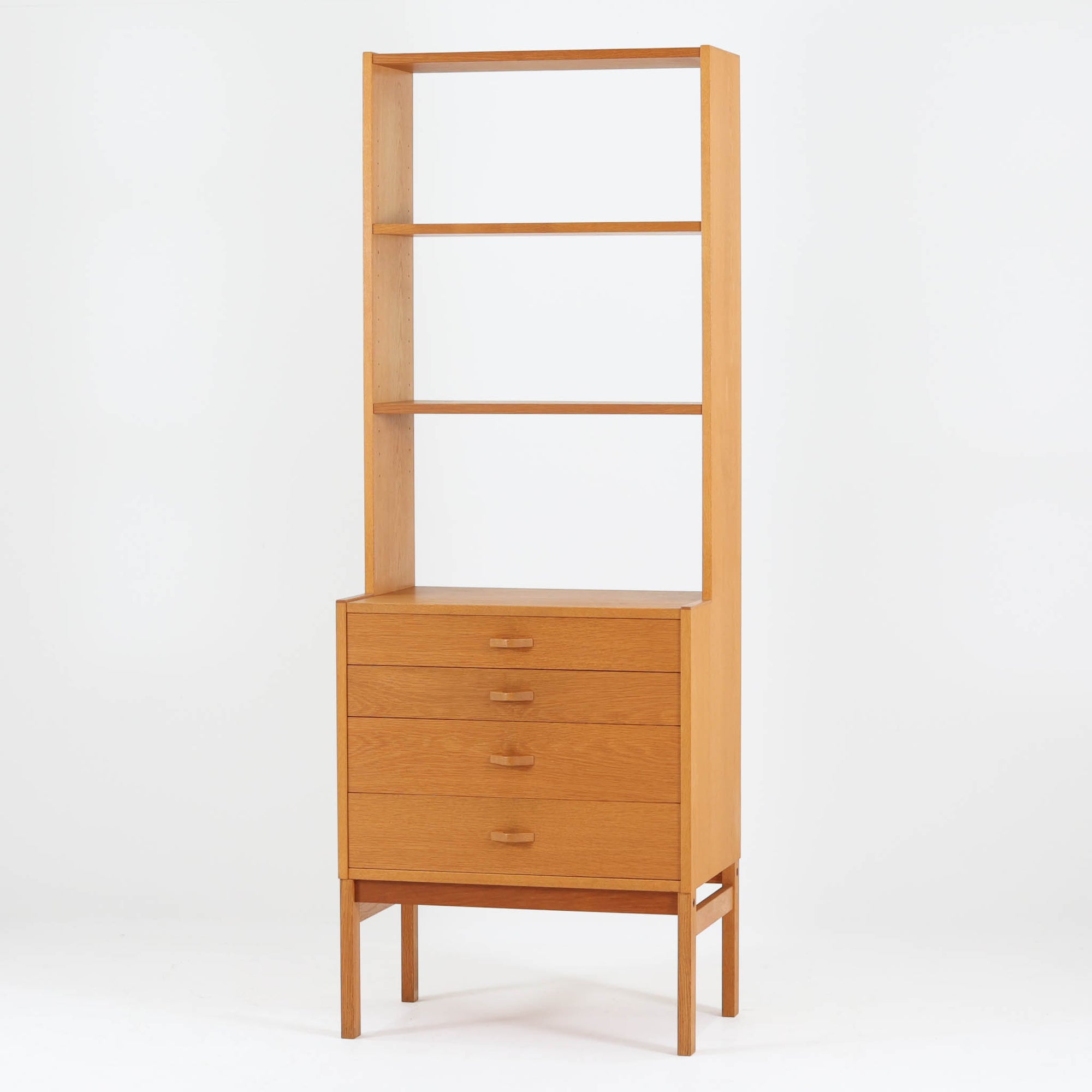 北欧らしい合理性と温もりを感じさせるスリムシェルフです。オーク材ならではの明るく素直な木目が全体に美しく広がり、経年によって落ち着いた表情へと変化しています。上部は抜け感のあるオープン棚構造で、書籍やオブジェ、器などを軽やかにディスプレイ可能。下部には4段の引き出しを備え、小物や生活用品をすっきりと収納できます。幅60cmのスリムな設計は、リビングや書斎、寝室など限られたスペースにも取り入れやすく、収納と飾る楽しみを両立できる北欧ビンテージならではの実用的な一台です。