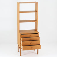 北欧らしい合理性と温もりを感じさせるスリムシェルフです。オーク材ならではの明るく素直な木目が全体に美しく広がり、経年によって落ち着いた表情へと変化しています。上部は抜け感のあるオープン棚構造で、書籍やオブジェ、器などを軽やかにディスプレイ可能。下部には4段の引き出しを備え、小物や生活用品をすっきりと収納できます。幅60cmのスリムな設計は、リビングや書斎、寝室など限られたスペースにも取り入れやすく、収納と飾る楽しみを両立できる北欧ビンテージならではの実用的な一台です。