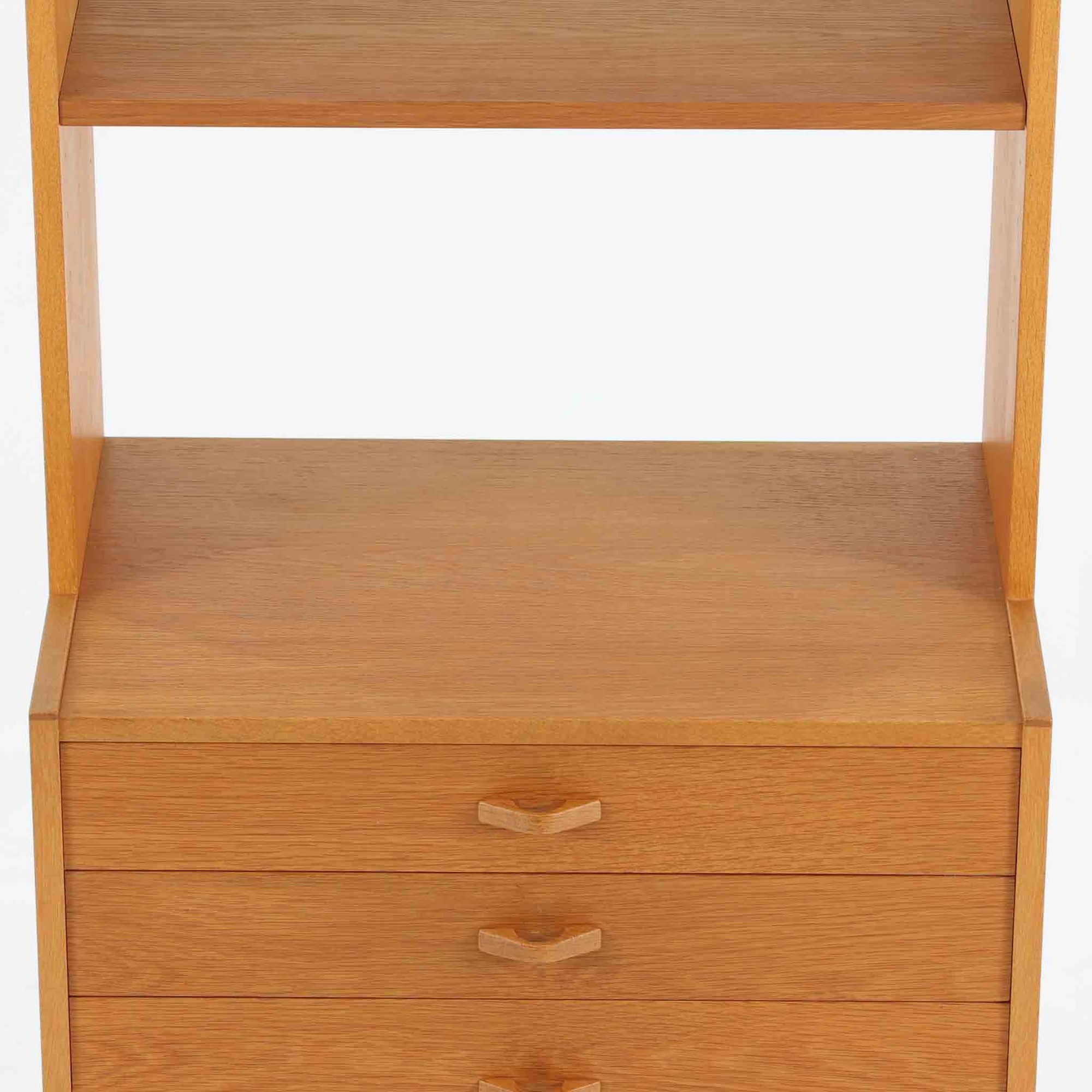 北欧らしい合理性と温もりを感じさせるスリムシェルフです。オーク材ならではの明るく素直な木目が全体に美しく広がり、経年によって落ち着いた表情へと変化しています。上部は抜け感のあるオープン棚構造で、書籍やオブジェ、器などを軽やかにディスプレイ可能。下部には4段の引き出しを備え、小物や生活用品をすっきりと収納できます。幅60cmのスリムな設計は、リビングや書斎、寝室など限られたスペースにも取り入れやすく、収納と飾る楽しみを両立できる北欧ビンテージならではの実用的な一台です。