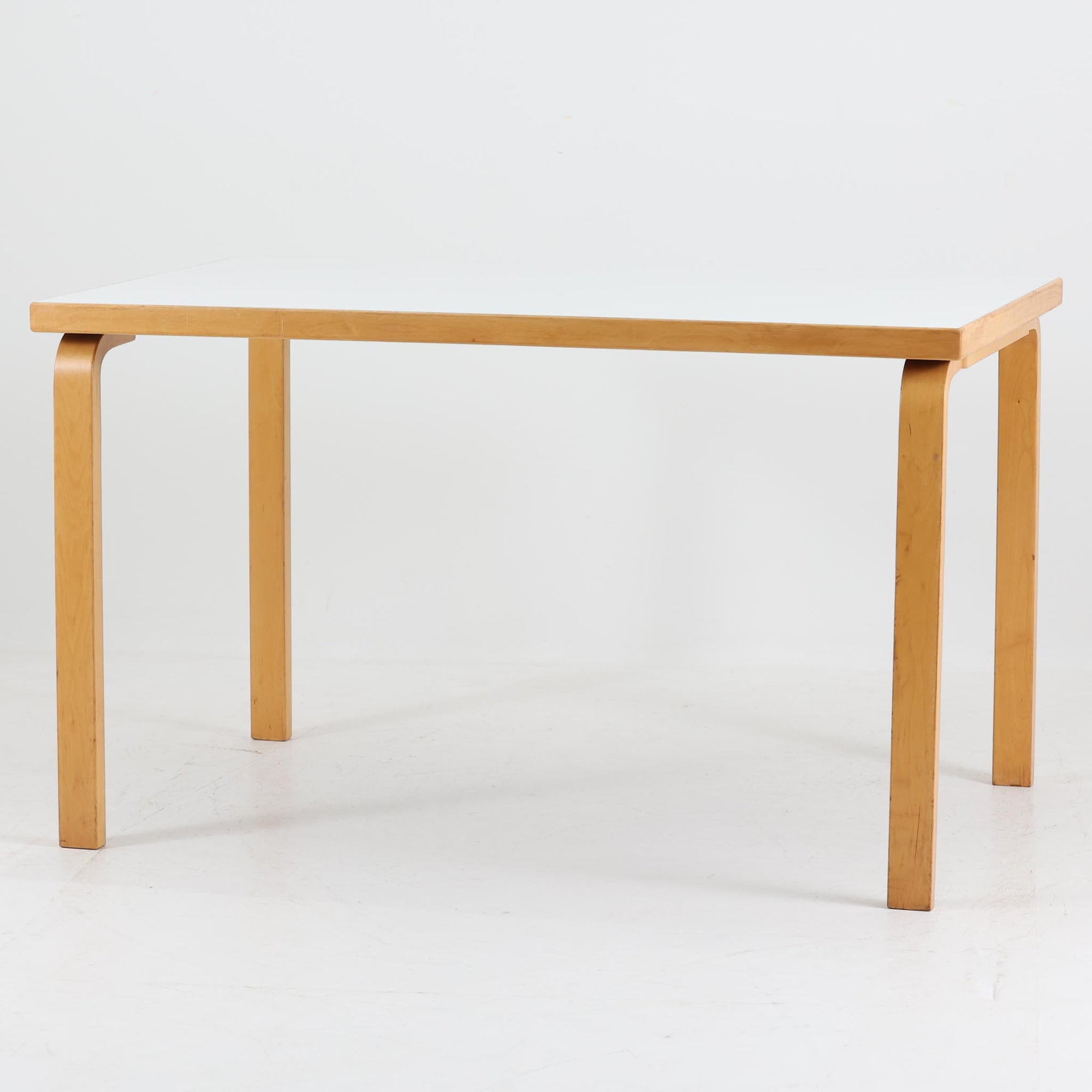 フィンランドの建築家Alvar Aaltoがデザインし、Artek社から製造されたダイニングテーブルです。温かみのあるバーチ材の脚と、耐久性に優れたホワイトラミネート天板の組み合わせが印象的で、Aalto特有の柔らかな曲線を描く脚部が、空間に優しい印象を与えます。幅120cmの扱いやすいサイズ感は、2〜4人での使用に適しており、ダイニングはもちろんワークデスクとしての活用もおすすめです。素材や構造に見られる北欧モダンデザインの美学と、長い年月を経た木部の風合いが魅力の一台です。