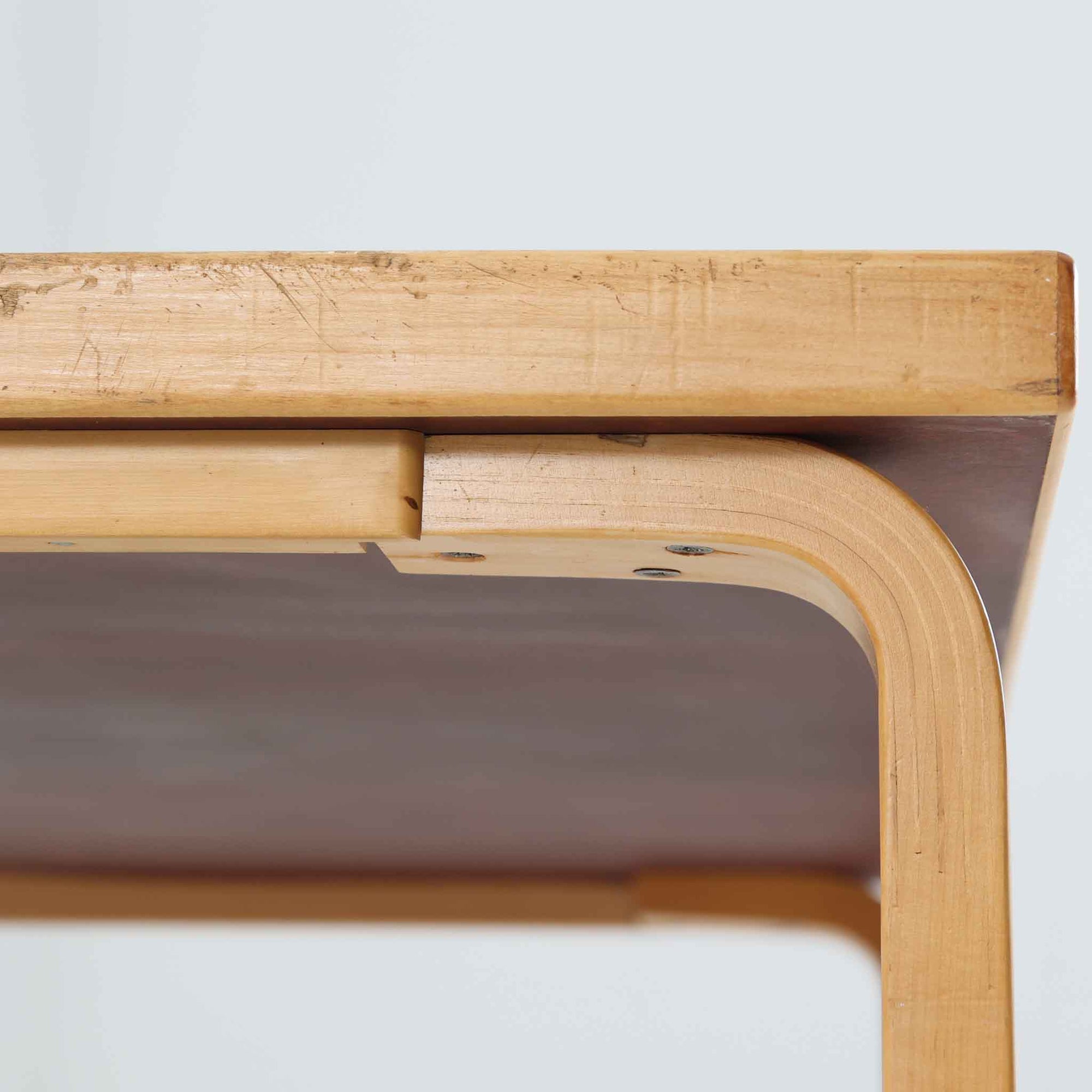 フィンランドの建築家Alvar Aaltoがデザインし、Artek社から製造されたダイニングテーブルです。温かみのあるバーチ材の脚と、耐久性に優れたホワイトラミネート天板の組み合わせが印象的で、Aalto特有の柔らかな曲線を描く脚部が、空間に優しい印象を与えます。幅120cmの扱いやすいサイズ感は、2〜4人での使用に適しており、ダイニングはもちろんワークデスクとしての活用もおすすめです。素材や構造に見られる北欧モダンデザインの美学と、長い年月を経た木部の風合いが魅力の一台です。