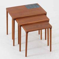 チーク材の温かみある木肌に、落ち着いたブルー系陶磁器タイルをあしらったネストテーブルは、北欧ビンテージらしい実用性と装飾性を兼ね備えたセットです。大小3台を重ねて収納できる合理的な構造で、必要に応じてサイドテーブルや補助台として柔軟に使い分けが可能。角を丸く仕上げた天板や細身の脚部には丁寧な木工技術が感じられ、経年により深みを増した表情が空間に静かな存在感を添えます。