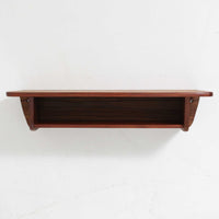 デンマーク製ウォールシェルフです。上質なチーク無垢材を使用し、滑らかなカーブを描く縁取りと丸みのあるフォルムが北欧家具らしい柔らかさを感じさせます。奥行きを抑えたコンパクトなサイズで、玄関や寝室、リビングのちょっとしたスペースにも取り付けやすい設計です。経年により深みを増したチーク材の美しい色合いが、壁面を上品に演出します。