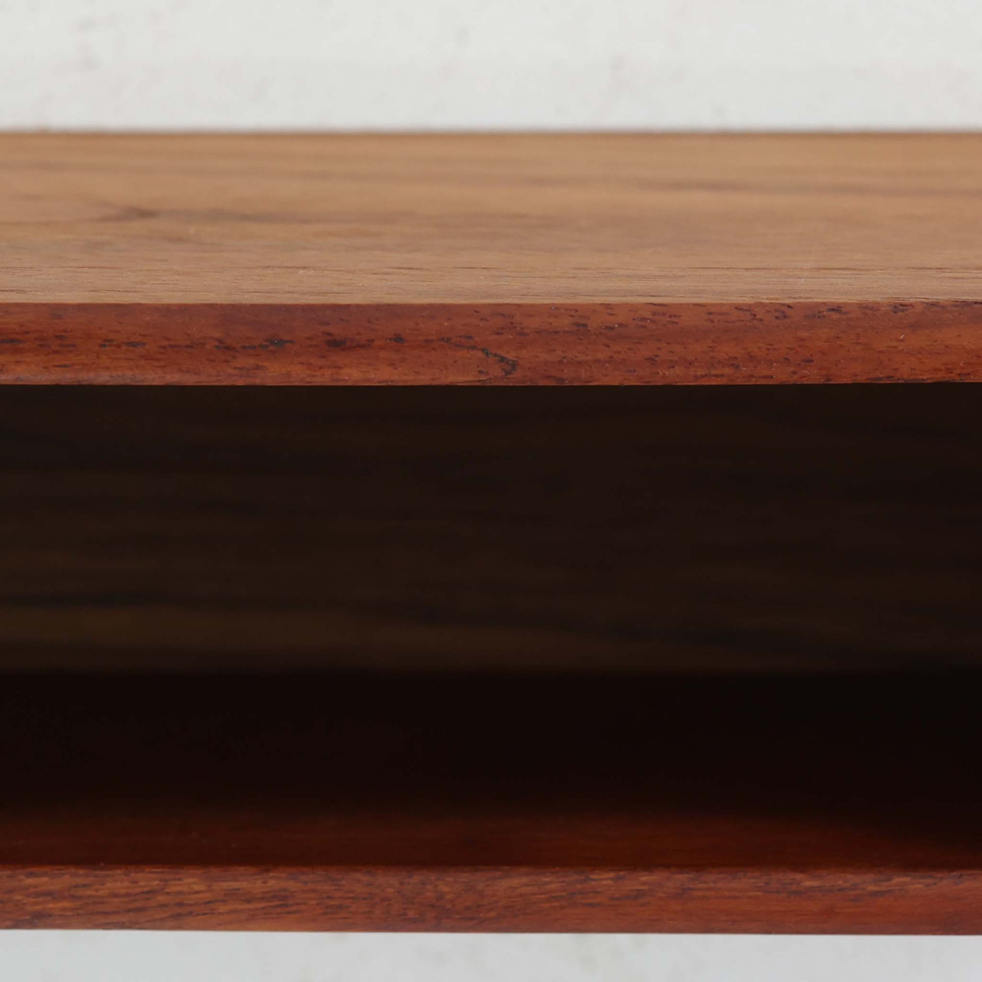 デンマーク製ウォールシェルフです。上質なチーク無垢材を使用し、滑らかなカーブを描く縁取りと丸みのあるフォルムが北欧家具らしい柔らかさを感じさせます。奥行きを抑えたコンパクトなサイズで、玄関や寝室、リビングのちょっとしたスペースにも取り付けやすい設計です。経年により深みを増したチーク材の美しい色合いが、壁面を上品に演出します。