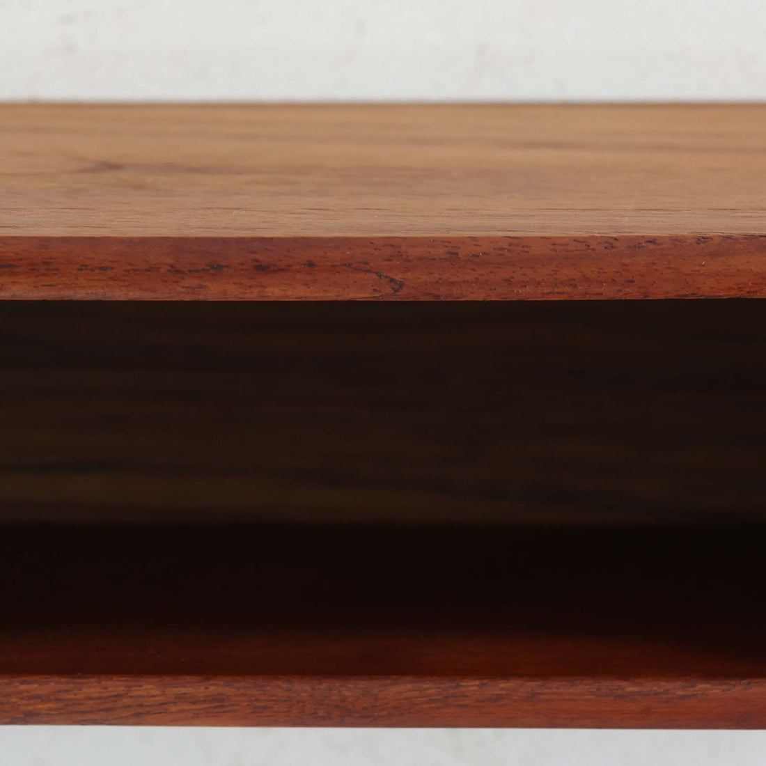 デンマーク製ウォールシェルフです。上質なチーク無垢材を使用し、滑らかなカーブを描く縁取りと丸みのあるフォルムが北欧家具らしい柔らかさを感じさせます。奥行きを抑えたコンパクトなサイズで、玄関や寝室、リビングのちょっとしたスペースにも取り付けやすい設計です。経年により深みを増したチーク材の美しい色合いが、壁面を上品に演出します。