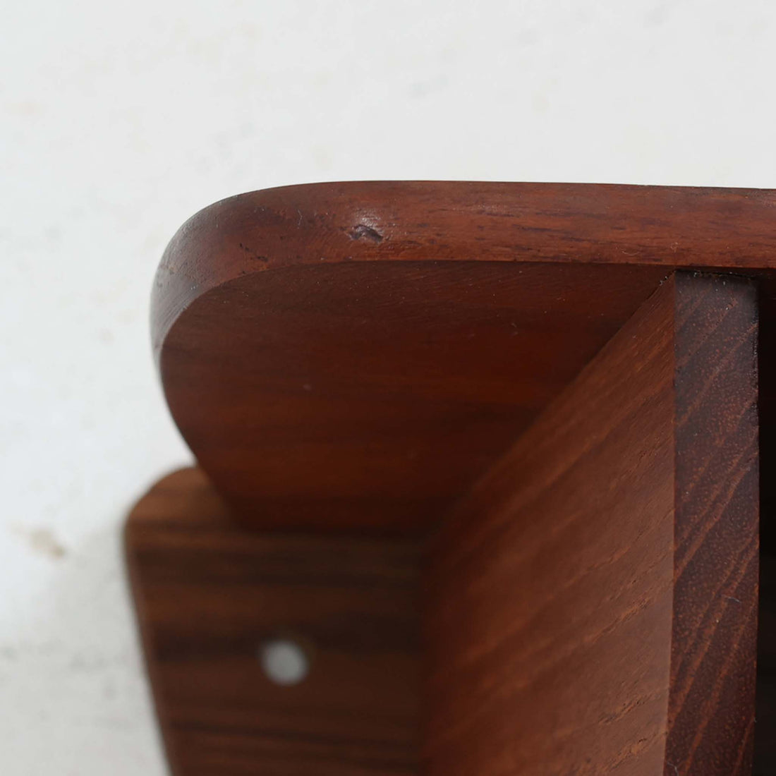 デンマーク製ウォールシェルフです。上質なチーク無垢材を使用し、滑らかなカーブを描く縁取りと丸みのあるフォルムが北欧家具らしい柔らかさを感じさせます。奥行きを抑えたコンパクトなサイズで、玄関や寝室、リビングのちょっとしたスペースにも取り付けやすい設計です。経年により深みを増したチーク材の美しい色合いが、壁面を上品に演出します。