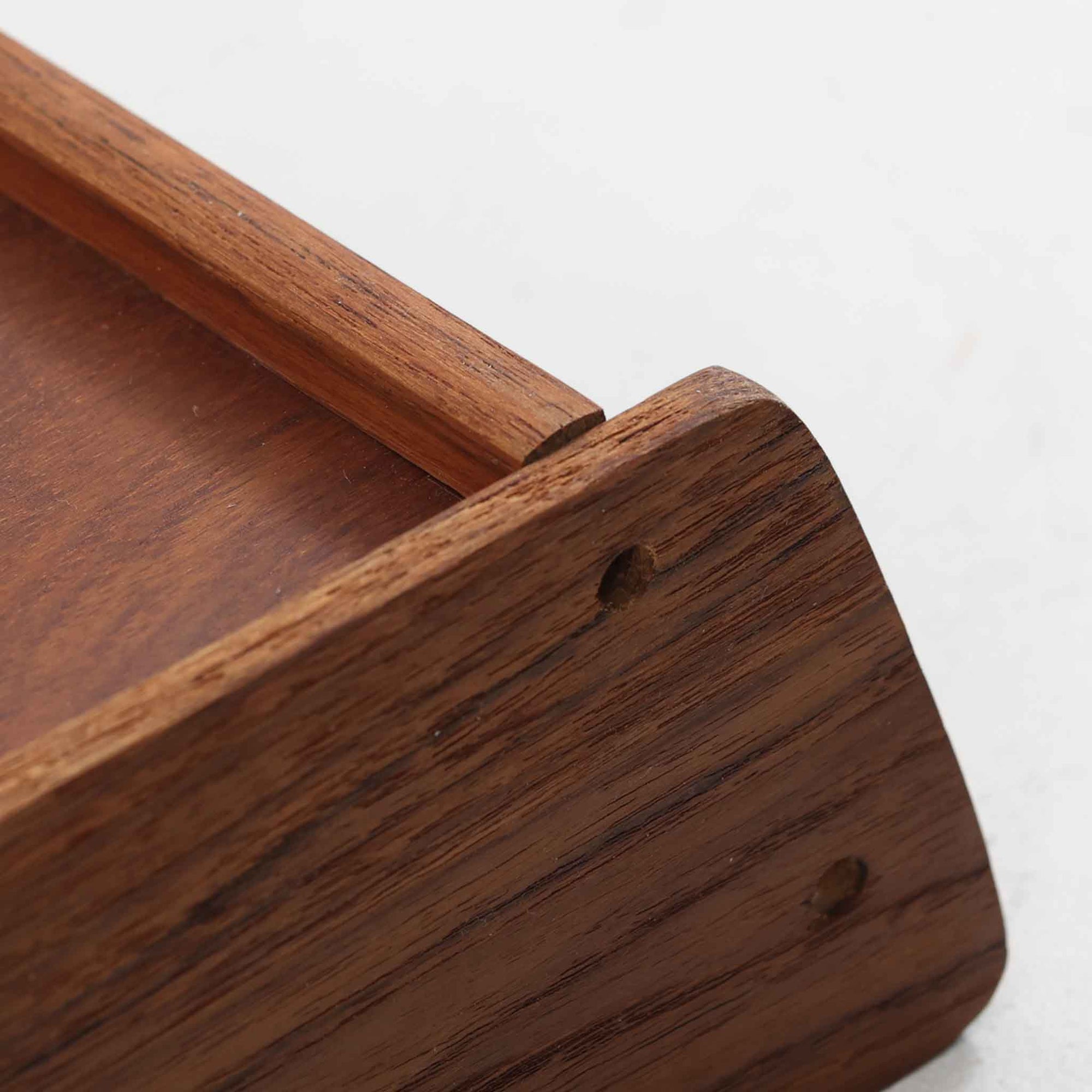 デンマーク製ウォールシェルフです。上質なチーク無垢材を使用し、滑らかなカーブを描く縁取りと丸みのあるフォルムが北欧家具らしい柔らかさを感じさせます。奥行きを抑えたコンパクトなサイズで、玄関や寝室、リビングのちょっとしたスペースにも取り付けやすい設計です。経年により深みを増したチーク材の美しい色合いが、壁面を上品に演出します。