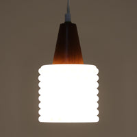 デンマーク製のペンダントライト、直径13cmです。ガラスシェードには立体的なドット模様が施され、点灯すると陰影が浮かび上がり独特の表情を生み出します。上部にはチーク材が用いられ、ガラスの繊細さと木の温もりが調和した北欧らしい意匠が魅力です。小ぶりなサイズながらも存在感があり、キッチンや廊下、ベッドサイドなど複数使いにも適しています。経年による素材の風合いがビンテージ品ならではの味わいを感じさせ、日常空間に個性を添える一品です。