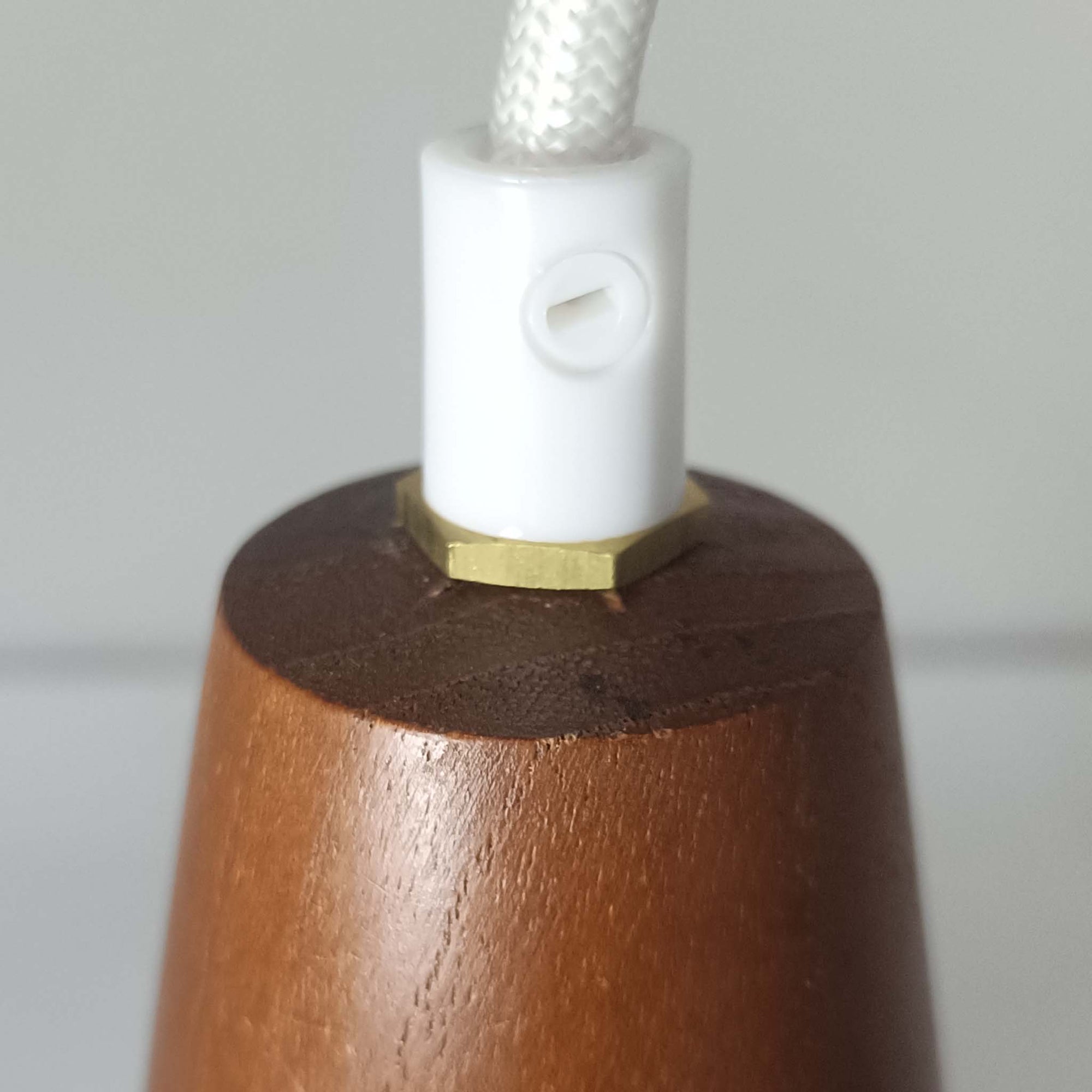 デンマーク製のペンダントライト、直径13cmです。ガラスシェードには立体的なドット模様が施され、点灯すると陰影が浮かび上がり独特の表情を生み出します。上部にはチーク材が用いられ、ガラスの繊細さと木の温もりが調和した北欧らしい意匠が魅力です。小ぶりなサイズながらも存在感があり、キッチンや廊下、ベッドサイドなど複数使いにも適しています。経年による素材の風合いがビンテージ品ならではの味わいを感じさせ、日常空間に個性を添える一品です。