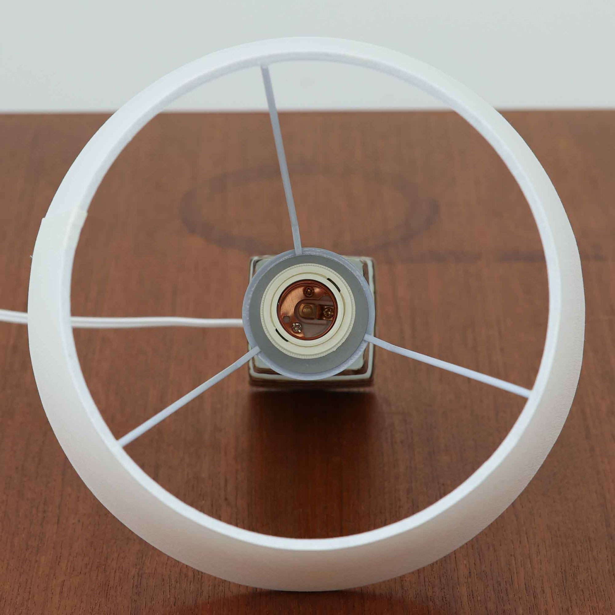 Nils Thorssonがデザインし、Royal Copenhagen社から発表された「BACA」シリーズのテーブルランプは、高さ39cmのバランスの取れたサイズ感で、北欧ビンテージらしい存在感を放ちます。陶磁器製のベースには細やかな装飾模様が施され、グラフィカルでありながら落ち着いた色調が空間に洗練された雰囲気を添えます。リネンシェードを透過する柔らかな光が温もりを演出し、リビングやベッドサイドに最適です。年月を経て深みを増した質感と工芸的な美しさを楽しめる一点物です。