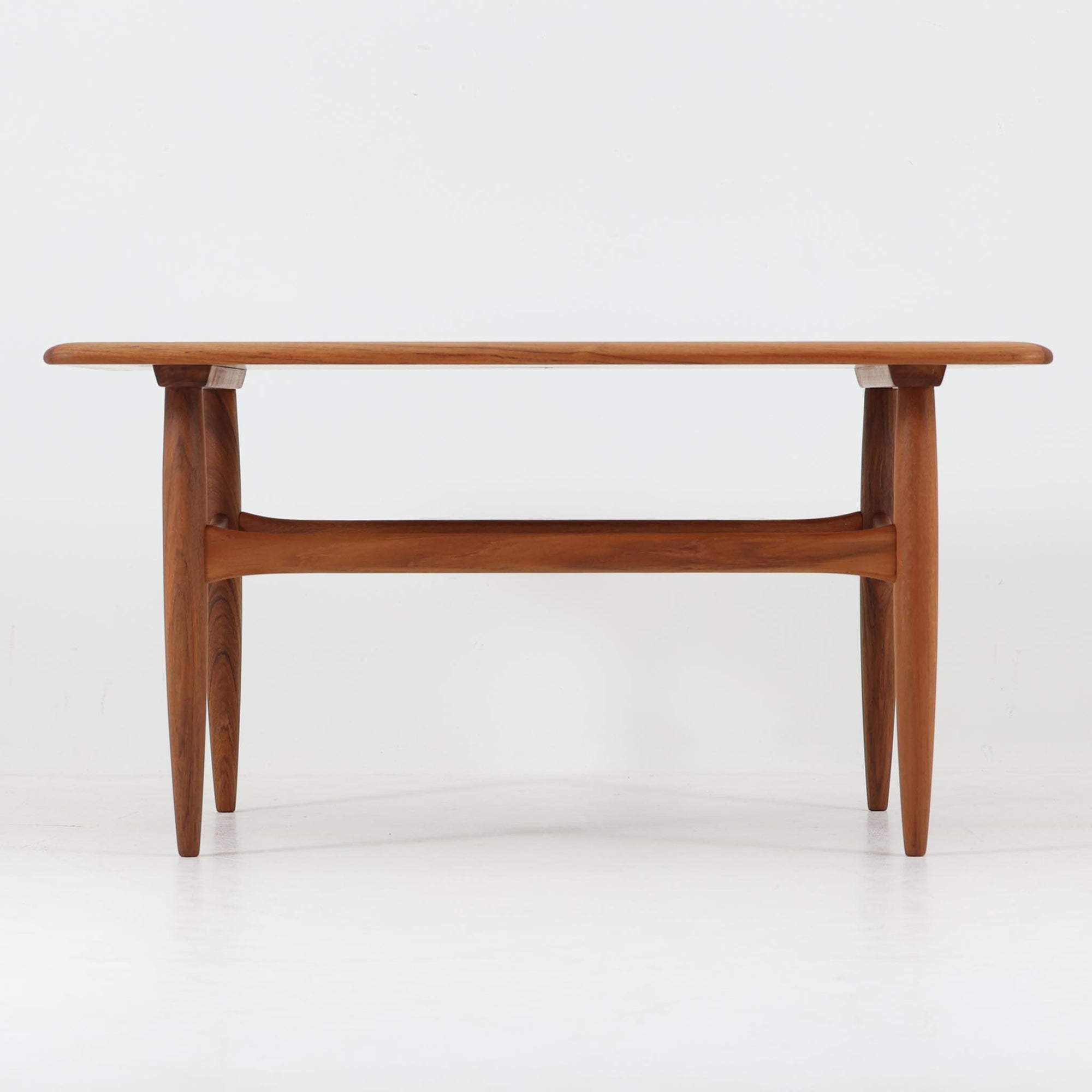 Kurt Ostervigが手がけ、Jason Mobler社により製造されたModel 195は、チーク材の温かみと滑らかな木肌が魅力の北欧ビンテージセンターテーブルです。天板は緩やかに面取りされ、脚部は丸みを帯びた先細りのフォルムで構成されており、軽やかさと安定感を両立しています。幕板の代わりにクロス状に配された貫が特徴で、構造美と機能性を兼ね備えたデザインは、ソファ前のテーブルとしてはもちろん、空間のアクセントとしても優れた存在感を放ちます。デンマーク製ビンテージならではの丁寧な仕上げと経年による風合いをお楽しみいただける一台です。