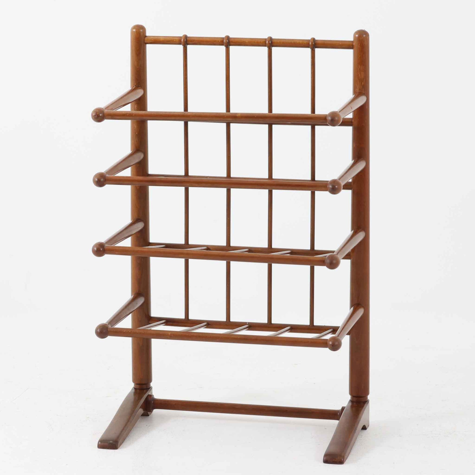 Frits Henningsenによってデザインされ、Andreas Tuck社から製造されたこちらのマガジンラックは、ビーチ材にステイン仕上げを施した温かみのある北欧ビンテージ家具です。前方に傾斜した4段構造の棚は、それぞれに仕切りがあり、雑誌や新聞を分類して収納しやすい設計となっています。丸みを帯びた支柱や棚先端の球状意匠に職人の丁寧な手仕事が感じられ、空間に柔らかな存在感を添える名作家具です。