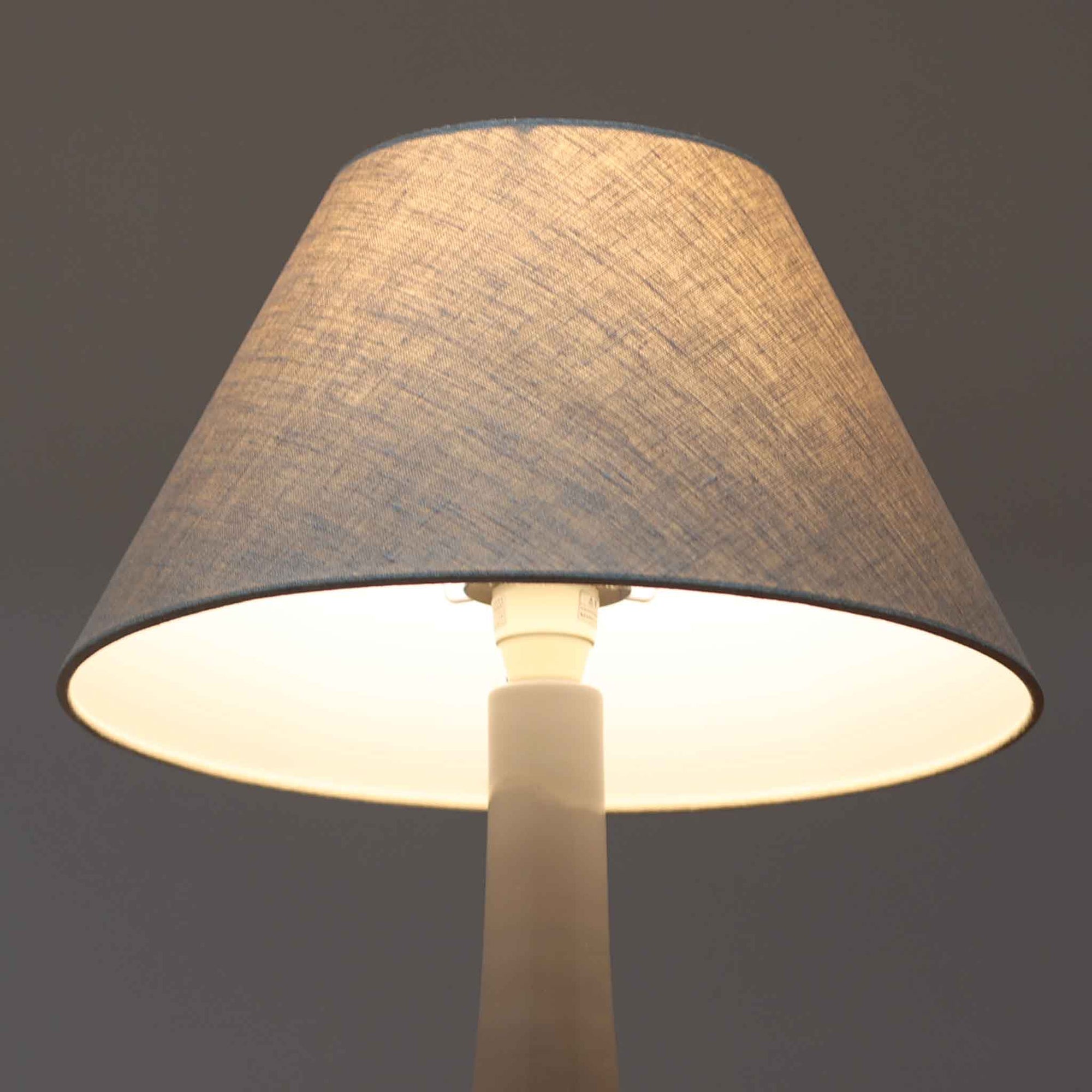 Royal Copenhagen社製のテーブルランプ「1013-3807」です。高さ50cmと存在感のある大きめサイズで、陶磁器ならではの艶やかな質感のベースにリネンシェードが組み合わされ、落ち着いた雰囲気を醸し出しています。クラシカルなフォルムに北欧らしい洗練されたデザインが融合し、点灯時には柔らかく温かな光が空間を包み込みます。リビングやベッドサイドのアクセントとしてはもちろん、インテリアオブジェとしても映える北欧ビンテージの逸品です。
