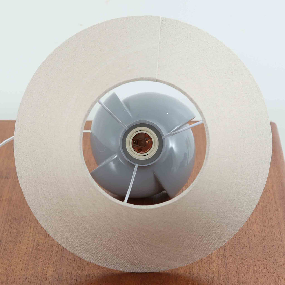 Royal Copenhagen社製のテーブルランプ「1013-3807」です。高さ50cmと存在感のある大きめサイズで、陶磁器ならではの艶やかな質感のベースにリネンシェードが組み合わされ、落ち着いた雰囲気を醸し出しています。クラシカルなフォルムに北欧らしい洗練されたデザインが融合し、点灯時には柔らかく温かな光が空間を包み込みます。リビングやベッドサイドのアクセントとしてはもちろん、インテリアオブジェとしても映える北欧ビンテージの逸品です。