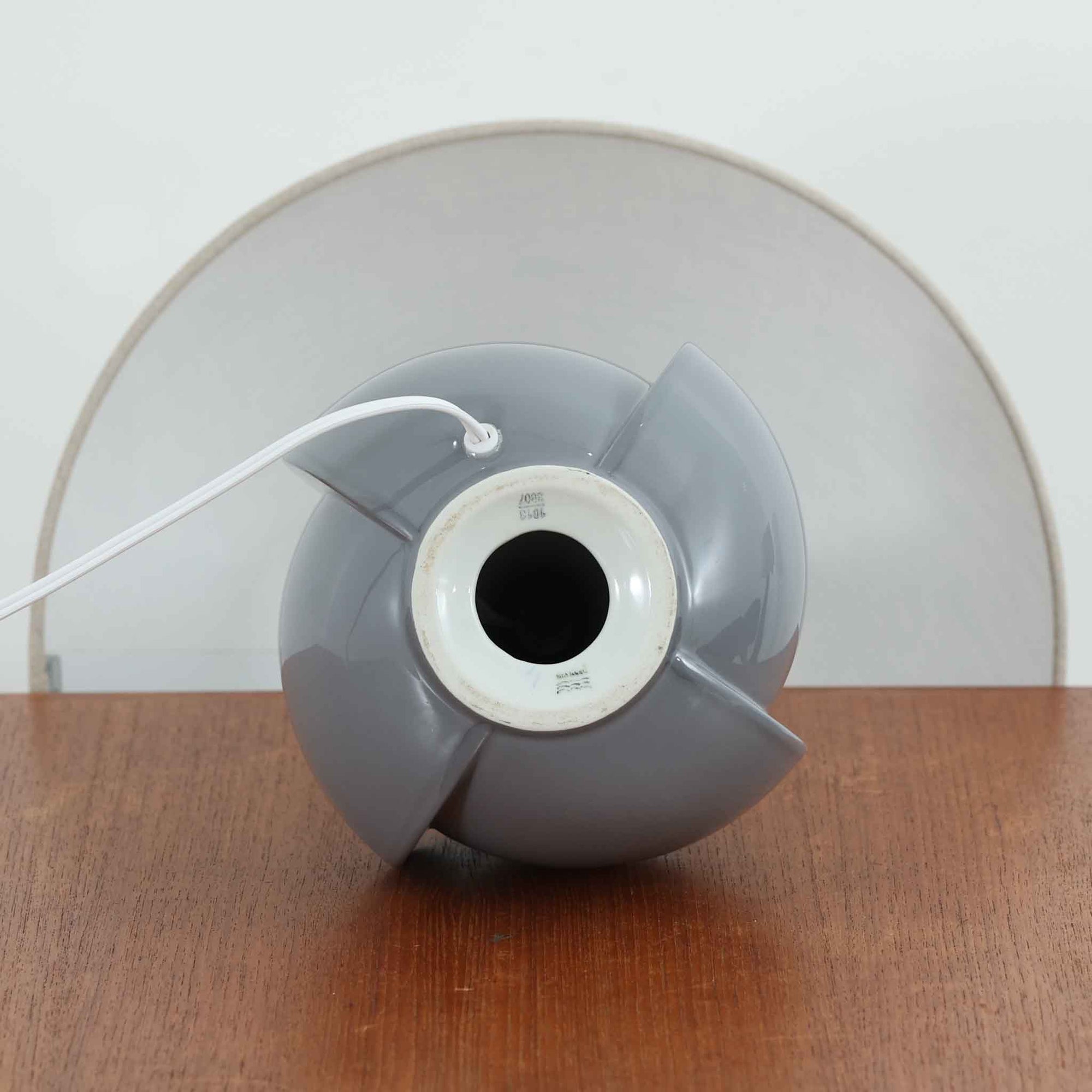 Royal Copenhagen社製のテーブルランプ「1013-3807」です。高さ50cmと存在感のある大きめサイズで、陶磁器ならではの艶やかな質感のベースにリネンシェードが組み合わされ、落ち着いた雰囲気を醸し出しています。クラシカルなフォルムに北欧らしい洗練されたデザインが融合し、点灯時には柔らかく温かな光が空間を包み込みます。リビングやベッドサイドのアクセントとしてはもちろん、インテリアオブジェとしても映える北欧ビンテージの逸品です。