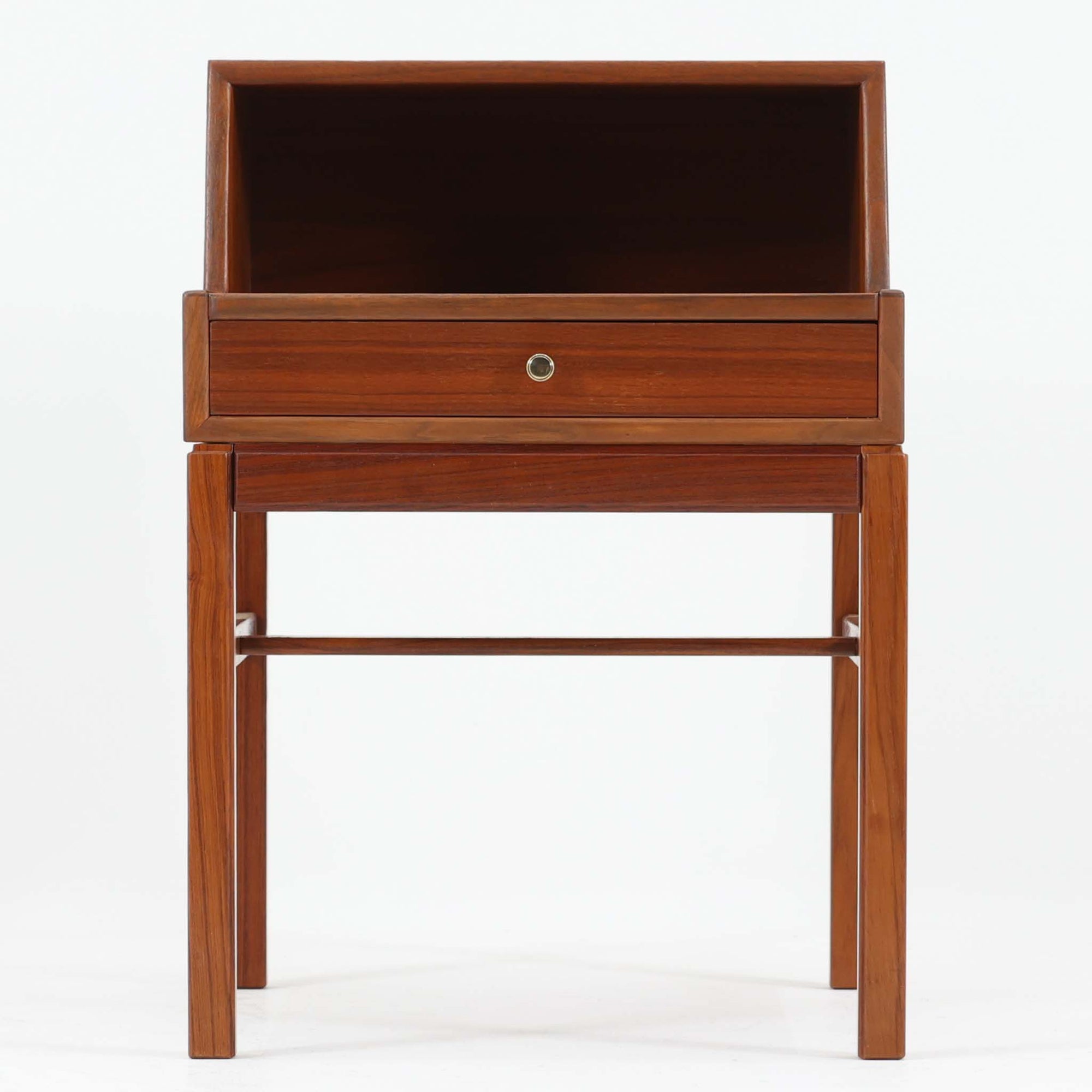 デンマーク製の北欧ビンテージサイドチェストです。チーク材の落ち着いた色合いと美しい木目が際立ち、奥行きをしっかりと確保した設計が実用性を高めています。上部はオープンスペースと、下段には小ぶりな引き出しを配置。真鍮調のつまみがさりげないアクセントとなり、直線的なフォルムとすらりとした脚部が軽やかな印象を与えます。ベッドサイドやリビングでの小物収納、簡易デスクとしても活躍し、経年による艶やかな風合いが空間に温もりを添える一台です。
