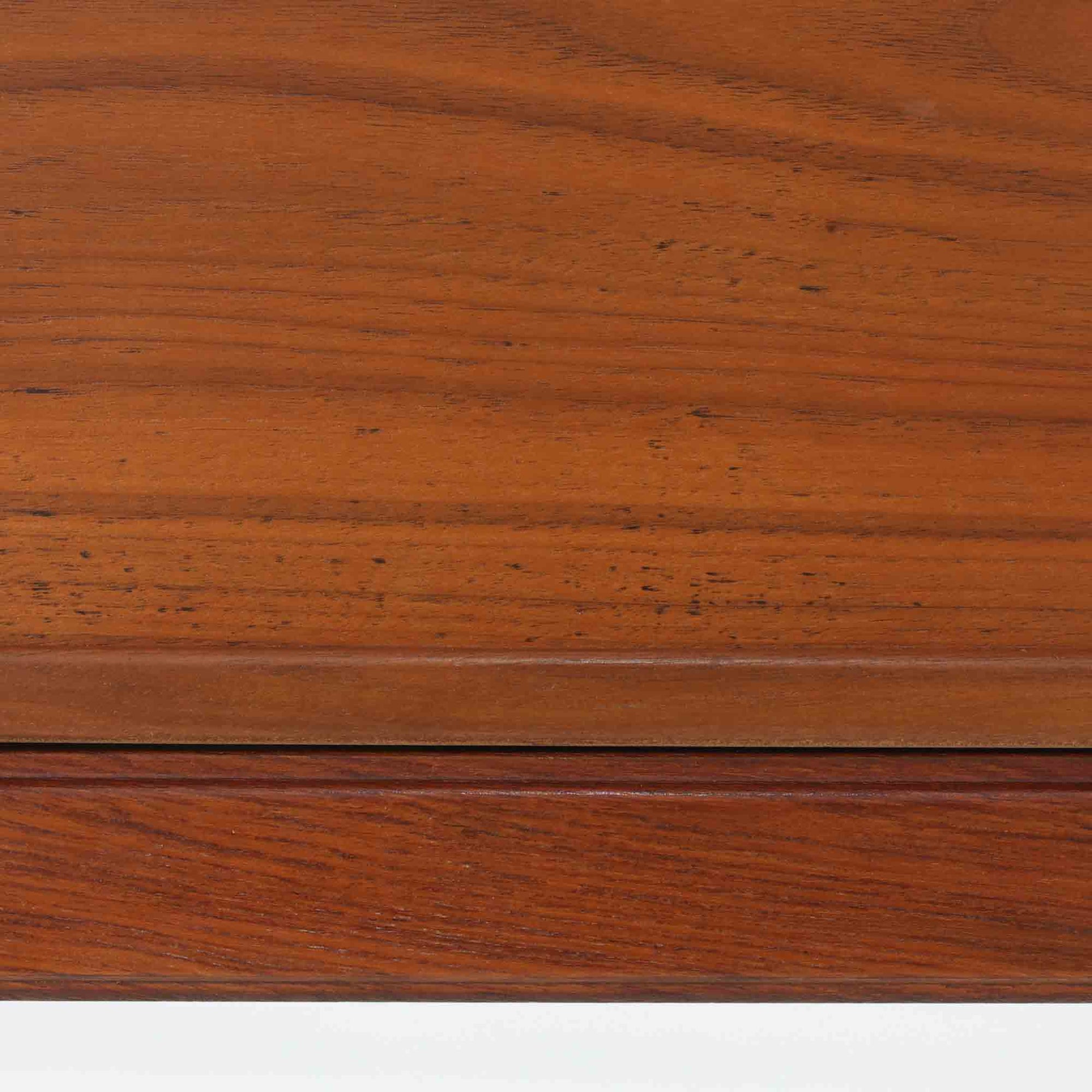 デンマーク製の北欧ビンテージサイドチェストです。チーク材の落ち着いた色合いと美しい木目が際立ち、奥行きをしっかりと確保した設計が実用性を高めています。上部はオープンスペースと、下段には小ぶりな引き出しを配置。真鍮調のつまみがさりげないアクセントとなり、直線的なフォルムとすらりとした脚部が軽やかな印象を与えます。ベッドサイドやリビングでの小物収納、簡易デスクとしても活躍し、経年による艶やかな風合いが空間に温もりを添える一台です。