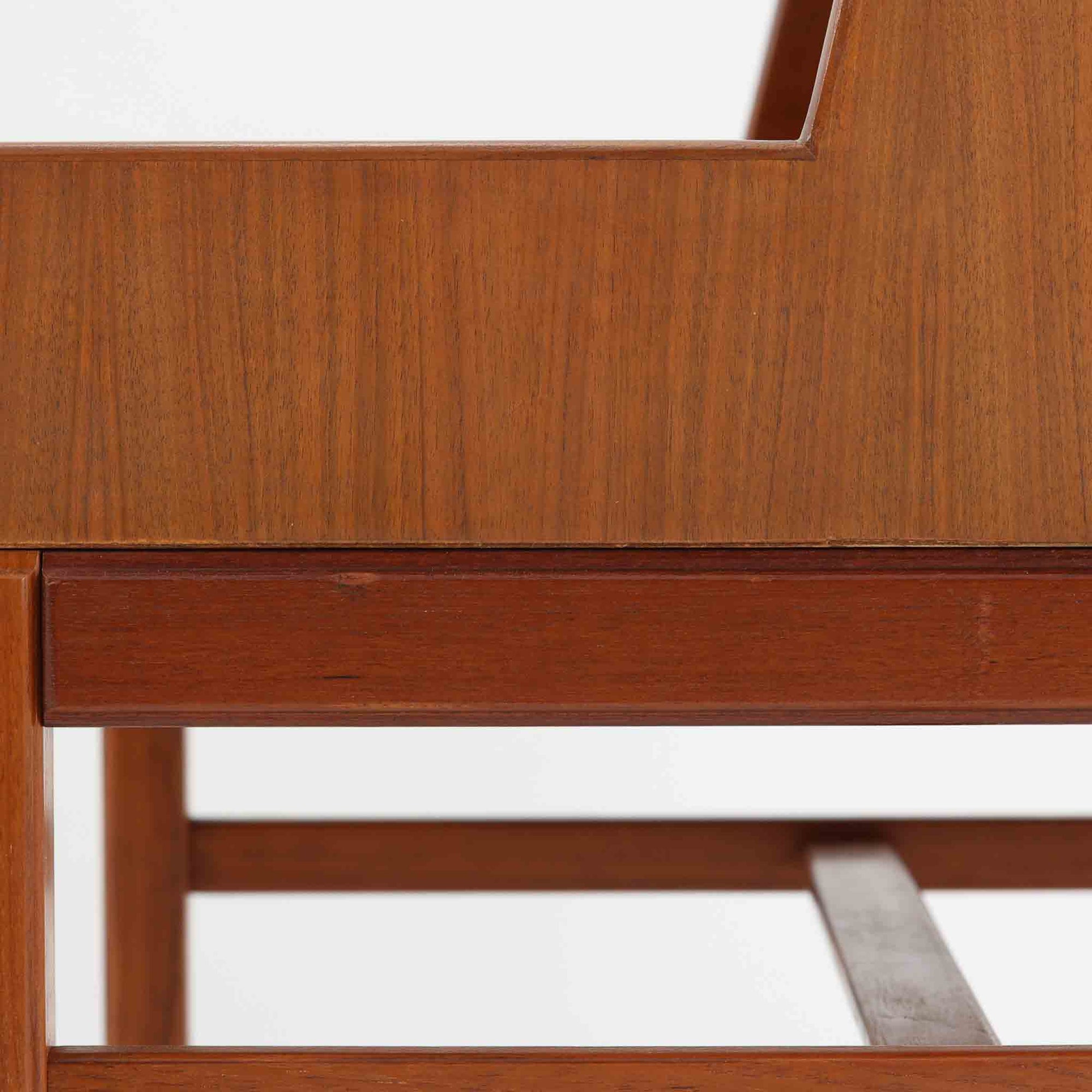 デンマーク製の北欧ビンテージサイドチェストです。チーク材の落ち着いた色合いと美しい木目が際立ち、奥行きをしっかりと確保した設計が実用性を高めています。上部はオープンスペースと、下段には小ぶりな引き出しを配置。真鍮調のつまみがさりげないアクセントとなり、直線的なフォルムとすらりとした脚部が軽やかな印象を与えます。ベッドサイドやリビングでの小物収納、簡易デスクとしても活躍し、経年による艶やかな風合いが空間に温もりを添える一台です。