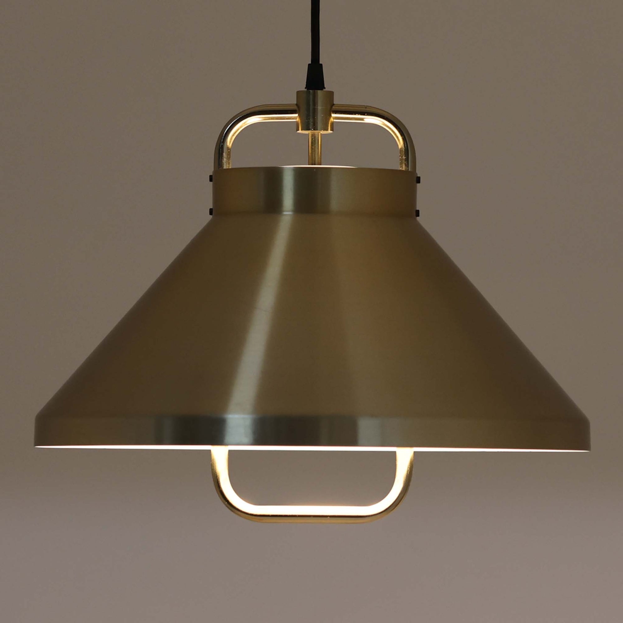 Jo Hammerborg（ヨー・ハーマボー）がFog & Morup（フォグ＆モーラップ）より発表した「Tarok」ペンダントライトです。直径41cmと存在感のあるサイズで、真鍮のような上品な質感をもつアルミ素材が用いられています。特徴的な円弧を描くフレームとシンプルながらも力強いシェードデザインは、ハーマボーらしいモダンな造形美を感じさせます。消灯時はオブジェのような美しさを放ち、点灯時には温かみのある光が広がり、ダイニングやリビングを上質な空間へと演出します。北欧モダンデザインの洗練を感じさせるビンテージアイテムです。