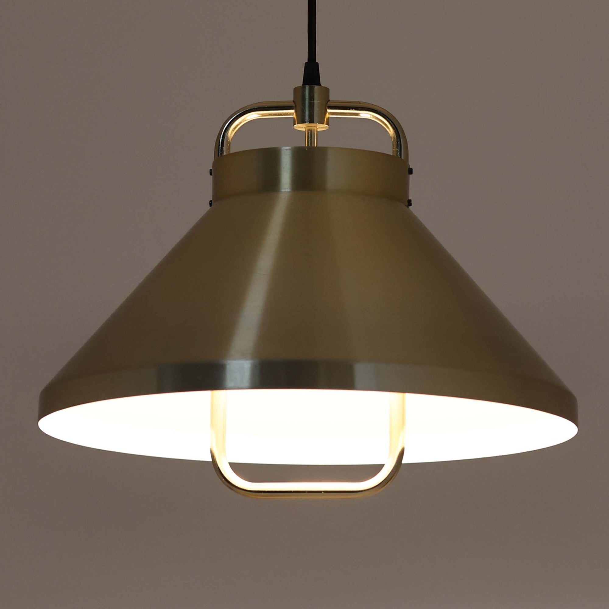 Jo Hammerborg（ヨー・ハーマボー）がFog &amp; Morup（フォグ＆モーラップ）より発表した「Tarok」ペンダントライトです。直径41cmと存在感のあるサイズで、真鍮のような上品な質感をもつアルミ素材が用いられています。特徴的な円弧を描くフレームとシンプルながらも力強いシェードデザインは、ハーマボーらしいモダンな造形美を感じさせます。消灯時はオブジェのような美しさを放ち、点灯時には温かみのある光が広がり、ダイニングやリビングを上質な空間へと演出します。北欧モダンデザインの洗練を感じさせるビンテージアイテムです。