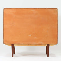 北欧ビンテージらしい端正な佇まいが魅力の5段チェストです。良質な木材を用いた本体は、横に流れる美しい木目に加え、角だけでなく前板を含む本体全体が緩やかな曲線を描く、有機的で上質なフォルムが特徴です。引き出し前板には手掛け一体型の彫り込みが施され、丸みを帯びた造形と相まって柔らかな印象を与えます。高い工作精度が感じられるクオリティの高い一台で、収納力に優れたサイズながら脚付き構造により軽やかさも備え、寝室やリビングの主収納として活躍します。Vordingborg Mobelfabrik社製と伝えられていますが確証はなく、メーカー不詳のビンテージ品としてご紹介します。経年変化によって深みを増した木肌が、空間に上質な存在感をもたらします。