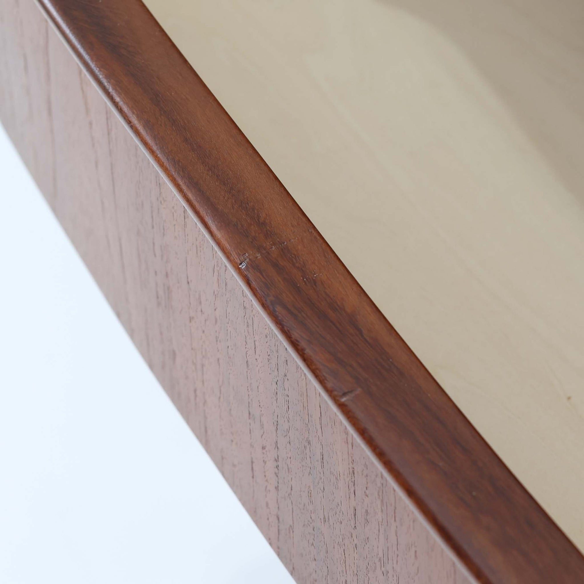 北欧ビンテージらしい端正な佇まいが魅力の5段チェストです。良質な木材を用いた本体は、横に流れる美しい木目に加え、角だけでなく前板を含む本体全体が緩やかな曲線を描く、有機的で上質なフォルムが特徴です。引き出し前板には手掛け一体型の彫り込みが施され、丸みを帯びた造形と相まって柔らかな印象を与えます。高い工作精度が感じられるクオリティの高い一台で、収納力に優れたサイズながら脚付き構造により軽やかさも備え、寝室やリビングの主収納として活躍します。Vordingborg Mobelfabrik社製と伝えられていますが確証はなく、メーカー不詳のビンテージ品としてご紹介します。経年変化によって深みを増した木肌が、空間に上質な存在感をもたらします。