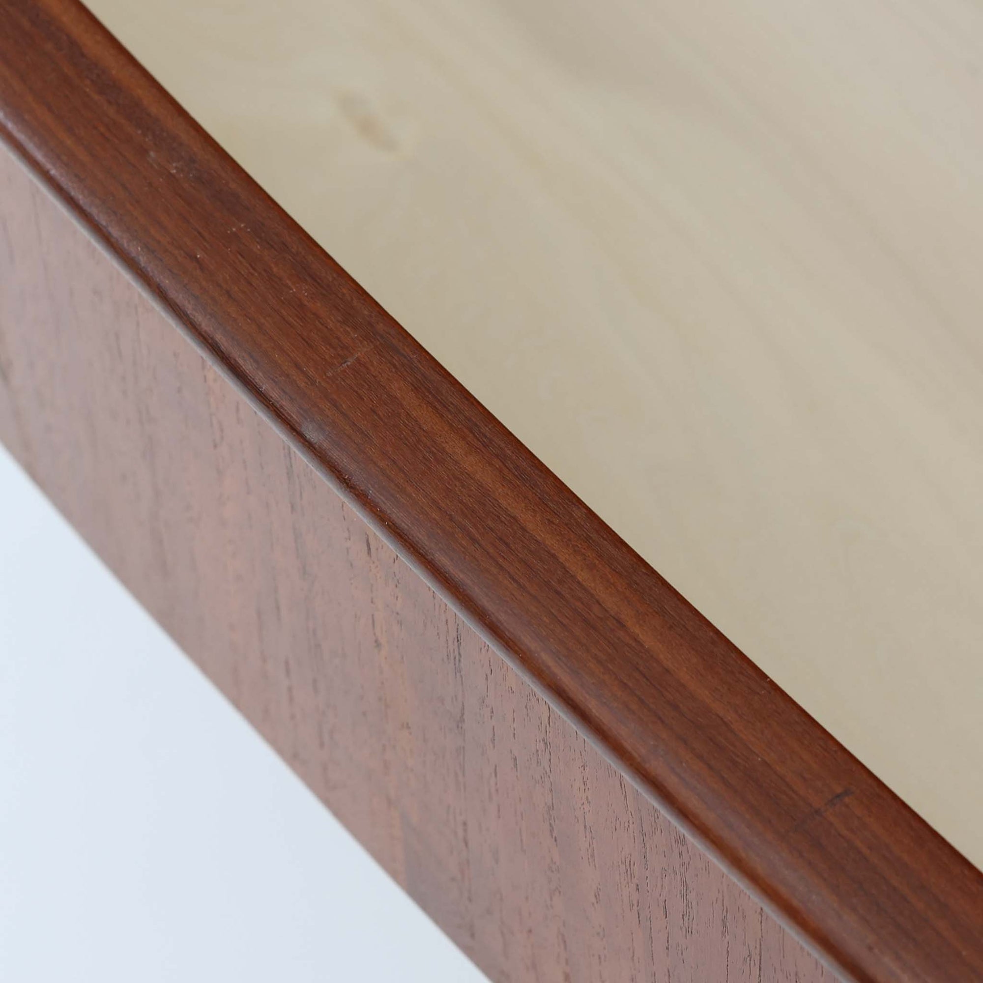 北欧ビンテージらしい端正な佇まいが魅力の5段チェストです。良質な木材を用いた本体は、横に流れる美しい木目に加え、角だけでなく前板を含む本体全体が緩やかな曲線を描く、有機的で上質なフォルムが特徴です。引き出し前板には手掛け一体型の彫り込みが施され、丸みを帯びた造形と相まって柔らかな印象を与えます。高い工作精度が感じられるクオリティの高い一台で、収納力に優れたサイズながら脚付き構造により軽やかさも備え、寝室やリビングの主収納として活躍します。Vordingborg Mobelfabrik社製と伝えられていますが確証はなく、メーカー不詳のビンテージ品としてご紹介します。経年変化によって深みを増した木肌が、空間に上質な存在感をもたらします。