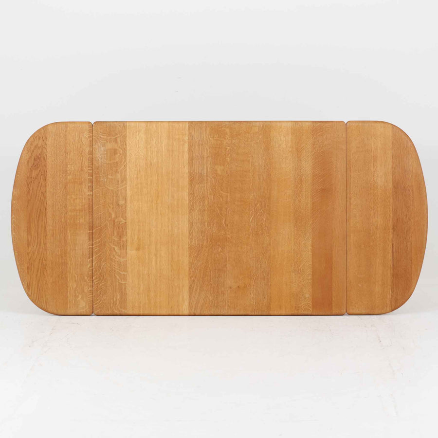 Hans J. Wegnerがデザインし、Getama社より製造されたセンターテーブル「GE82」は、丸脚の意匠が特徴で、四角脚の「GE85」と同時期にデザインされたといわれています。バタフライ構造による拡張機能を備えた北欧ビンテージ家具で、オーク無垢材を贅沢に使用し、幅103cmから160cmへと用途に応じてサイズ調整が可能。普段はコンパクトに、来客時には広々と使える実用性が魅力です。シンプルで力強いフォルムと無垢材ならではの豊かな木目は、年月を経て一層の味わいを増し、空間に温もりと存在感を添えます。