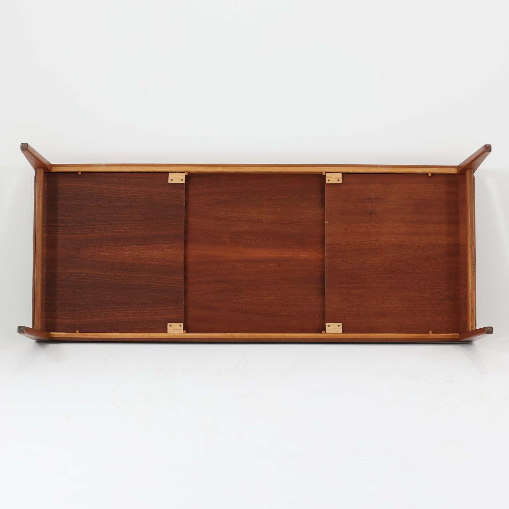 チーク材を用いたデンマーク製の拡張板付きセンターテーブルです。直線的で軽やかなフレーム構造と、脚部から天板へとつながる端正な接合部に北欧ビンテージらしい丁寧なつくりが感じられます。拡張板を引き出すことで天板幅を大きく広げることができ、来客時や作業スペースとしても柔軟に対応します。深みを増したチークの色合いと美しい木目が空間に落ち着きを与え、リビングの主役として長く愛用できる一台です。拡張板はチーク材のほか、黒のラミネート仕上げの2種類が備わっており、用途に応じて使い分けが可能です。ラミネート面は輪染みがつきにくく、作業用や来客時にも気兼ねなく使える実用性を備えています。