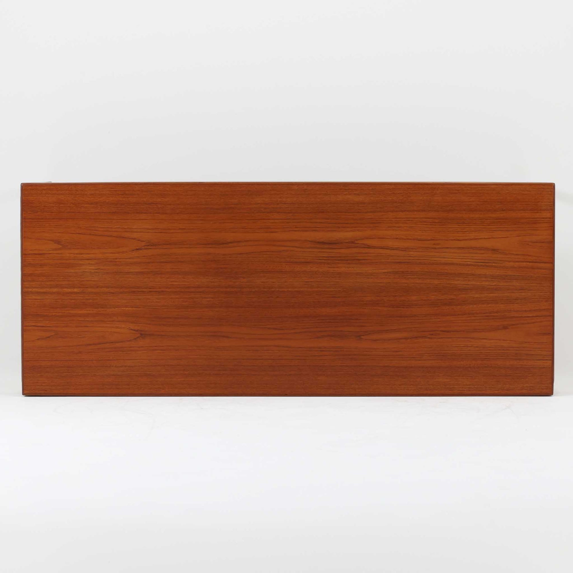 チーク材を用いたデンマーク製の拡張板付きセンターテーブルです。直線的で軽やかなフレーム構造と、脚部から天板へとつながる端正な接合部に北欧ビンテージらしい丁寧なつくりが感じられます。拡張板を引き出すことで天板幅を大きく広げることができ、来客時や作業スペースとしても柔軟に対応します。深みを増したチークの色合いと美しい木目が空間に落ち着きを与え、リビングの主役として長く愛用できる一台です。拡張板はチーク材のほか、黒のラミネート仕上げの2種類が備わっており、用途に応じて使い分けが可能です。ラミネート面は輪染みがつきにくく、作業用や来客時にも気兼ねなく使える実用性を備えています。