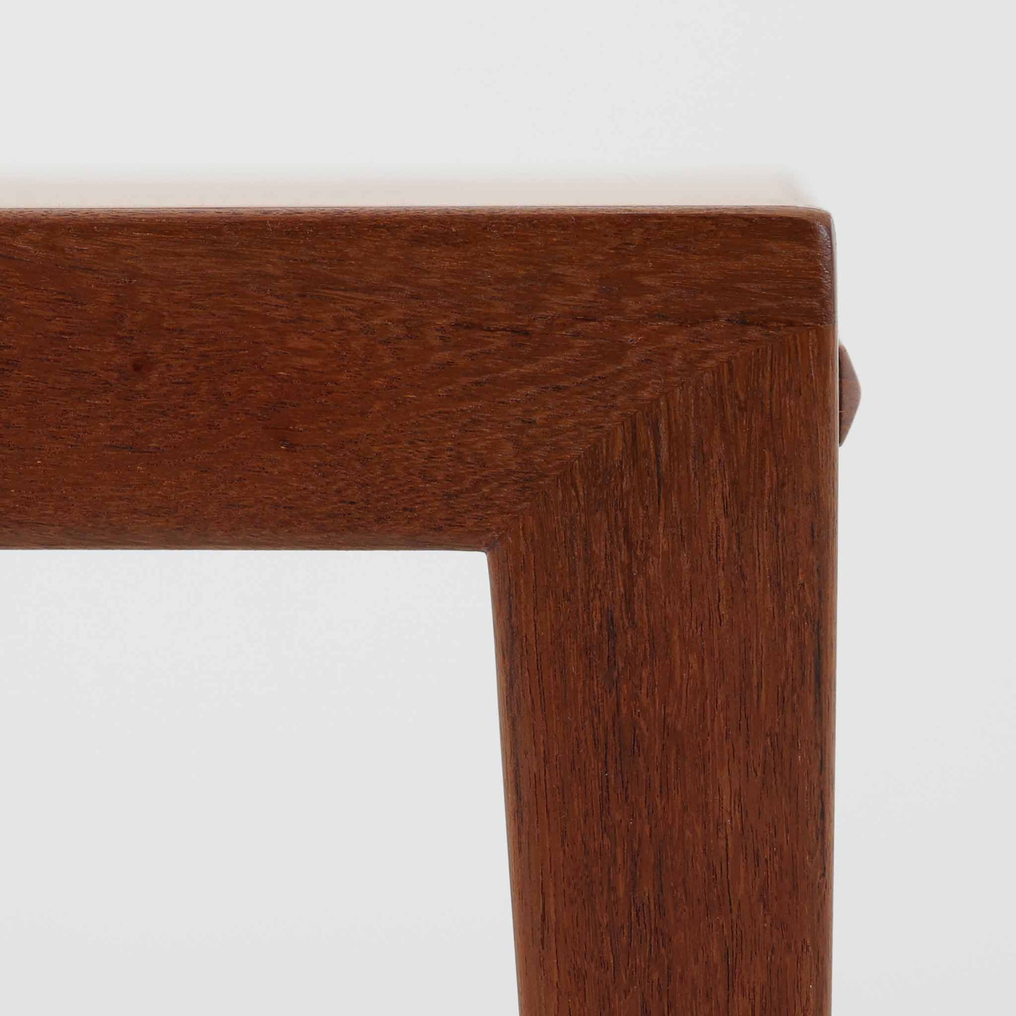 チーク材を用いたデンマーク製の拡張板付きセンターテーブルです。直線的で軽やかなフレーム構造と、脚部から天板へとつながる端正な接合部に北欧ビンテージらしい丁寧なつくりが感じられます。拡張板を引き出すことで天板幅を大きく広げることができ、来客時や作業スペースとしても柔軟に対応します。深みを増したチークの色合いと美しい木目が空間に落ち着きを与え、リビングの主役として長く愛用できる一台です。拡張板はチーク材のほか、黒のラミネート仕上げの2種類が備わっており、用途に応じて使い分けが可能です。ラミネート面は輪染みがつきにくく、作業用や来客時にも気兼ねなく使える実用性を備えています。