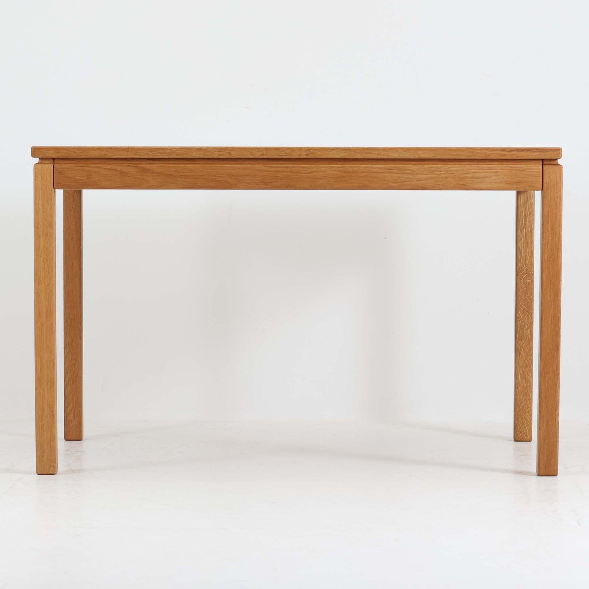 デンマークの家具メーカーBrodrene Andersen（ブロデルネ・アンデルセン）によるオーク無垢材のダイニングテーブルです。すっきりとした直線的な脚部と控えめな面取りが施された天板が美しく、素材の質感と職人技が際立つ仕上がりです。堅牢でありながら軽やかな印象を持ち、オーク特有の温かみある色調が空間に自然と馴染みます。幅115cmのコンパクトサイズで、ダイニングだけでなくワークデスクとしても使いやすい一台。北欧らしいシンプルなデザインと確かな作りが魅力のビンテージテーブルです。