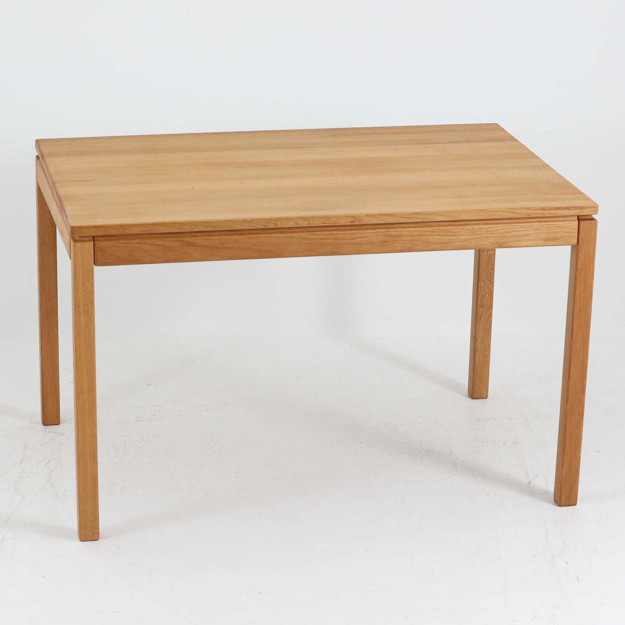 デンマークの家具メーカーBrodrene Andersen（ブロデルネ・アンデルセン）によるオーク無垢材のダイニングテーブルです。すっきりとした直線的な脚部と控えめな面取りが施された天板が美しく、素材の質感と職人技が際立つ仕上がりです。堅牢でありながら軽やかな印象を持ち、オーク特有の温かみある色調が空間に自然と馴染みます。幅115cmのコンパクトサイズで、ダイニングだけでなくワークデスクとしても使いやすい一台。北欧らしいシンプルなデザインと確かな作りが魅力のビンテージテーブルです。