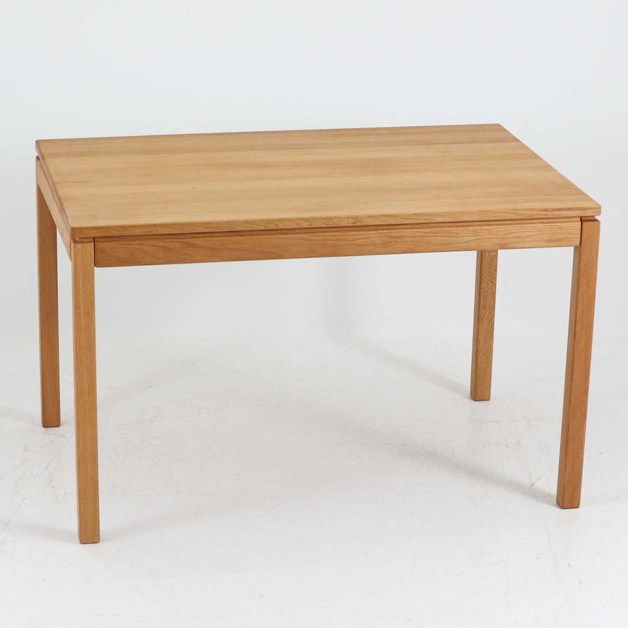 デンマークの家具メーカーBrodrene Andersen（ブロデルネ・アンデルセン）によるオーク無垢材のダイニングテーブルです。すっきりとした直線的な脚部と控えめな面取りが施された天板が美しく、素材の質感と職人技が際立つ仕上がりです。堅牢でありながら軽やかな印象を持ち、オーク特有の温かみある色調が空間に自然と馴染みます。幅115cmのコンパクトサイズで、ダイニングだけでなくワークデスクとしても使いやすい一台。北欧らしいシンプルなデザインと確かな作りが魅力のビンテージテーブルです。