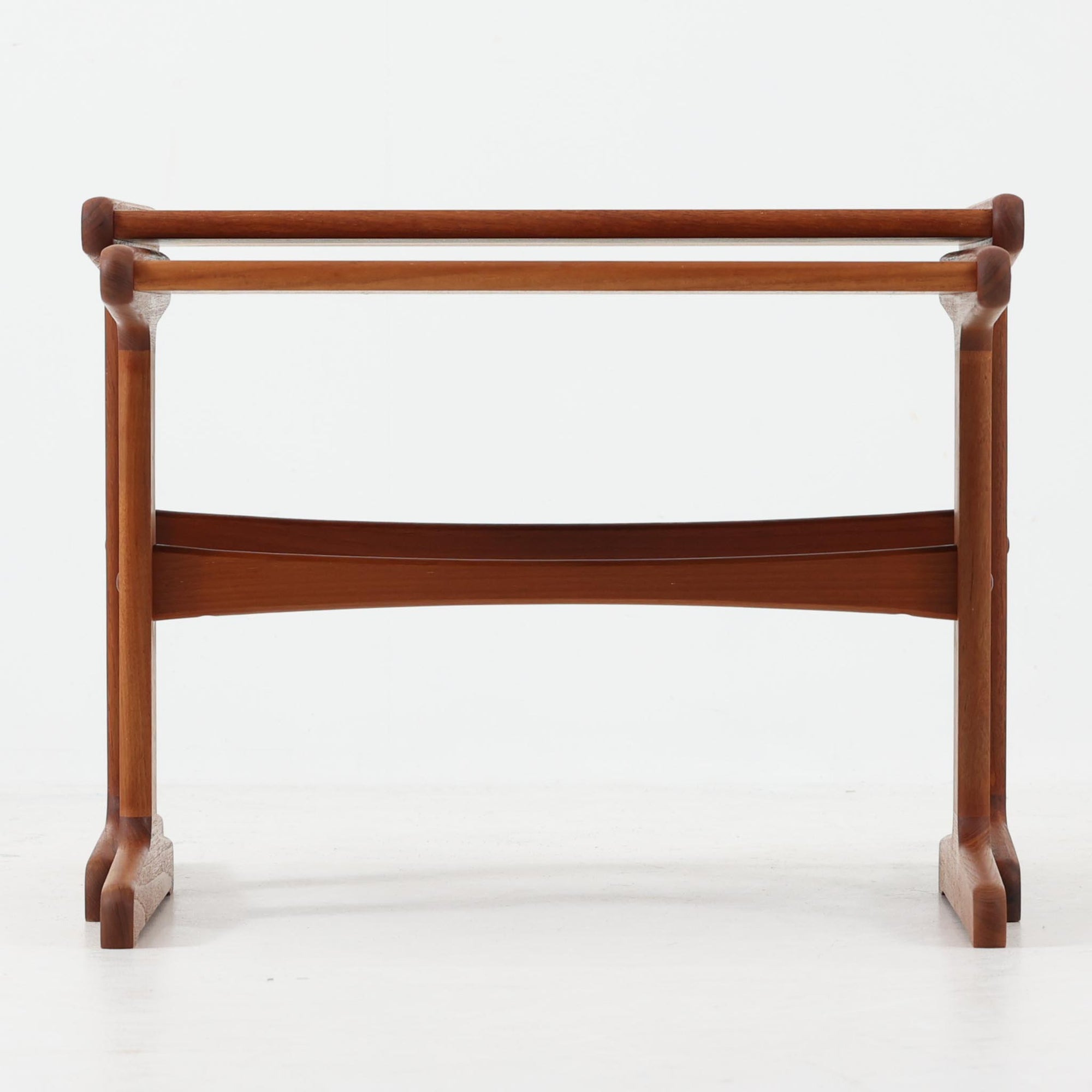 北欧ビンテージらしい合理性と温もりを感じさせるネストテーブルで、上下に重ねて使える構造により、限られた空間でも柔軟な使い方ができる実用的な一式です。素材には良質なチーク材が用いられ、木目の美しさと滑らかな手触りが際立ち、側板や脚部に見られるやわらかな曲線が全体に軽やかな印象を与えています。ネストテーブルではありますが、上下は深く内部に収まる仕様ではなく、軽く差し込む程度の構造となっており、単体でサイドテーブルや花台として使うほか、来客時には引き出して補助天板としても活躍します。経年変化によって深みを増した木肌が、空間に落ち着きと上質感をもたらします。