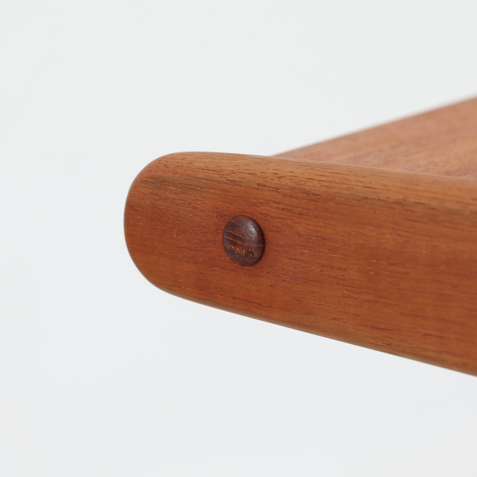 北欧ビンテージらしい合理性と温もりを感じさせるネストテーブルで、上下に重ねて使える構造により、限られた空間でも柔軟な使い方ができる実用的な一式です。素材には良質なチーク材が用いられ、木目の美しさと滑らかな手触りが際立ち、側板や脚部に見られるやわらかな曲線が全体に軽やかな印象を与えています。ネストテーブルではありますが、上下は深く内部に収まる仕様ではなく、軽く差し込む程度の構造となっており、単体でサイドテーブルや花台として使うほか、来客時には引き出して補助天板としても活躍します。経年変化によって深みを増した木肌が、空間に落ち着きと上質感をもたらします。