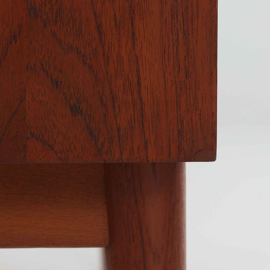 Johannes Sorth（ヨハネス・ソース）によるデザインで、Nexo Mobelfabrik社より製造されたチーク材のディスプレイシェルフです。上部の棚は本やオブジェを美しく飾ることができ、下部には引き戸収納を備え、実用性にも優れています。緩やかな曲線を描く側面のデザインが柔らかな印象を与え、北欧家具らしい温もりと機能美が感じられる一台です。脚部の細身のフォルムが軽やかさを演出し、リビングや書斎、ダイニングなど幅広い空間に調和します。