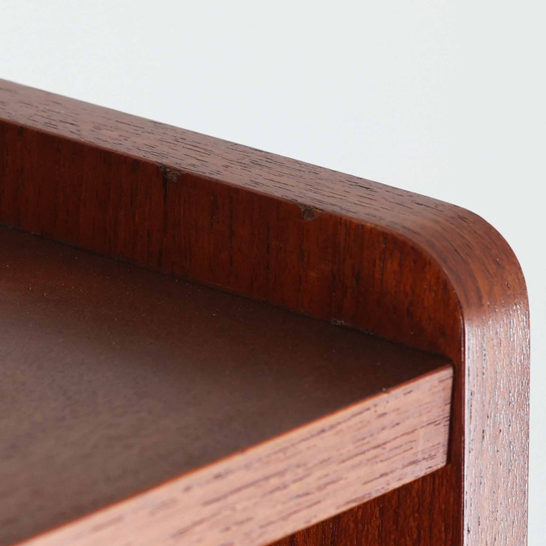 Johannes Sorth（ヨハネス・ソース）によるデザインで、Nexo Mobelfabrik社より製造されたチーク材のディスプレイシェルフです。上部の棚は本やオブジェを美しく飾ることができ、下部には引き戸収納を備え、実用性にも優れています。緩やかな曲線を描く側面のデザインが柔らかな印象を与え、北欧家具らしい温もりと機能美が感じられる一台です。脚部の細身のフォルムが軽やかさを演出し、リビングや書斎、ダイニングなど幅広い空間に調和します。