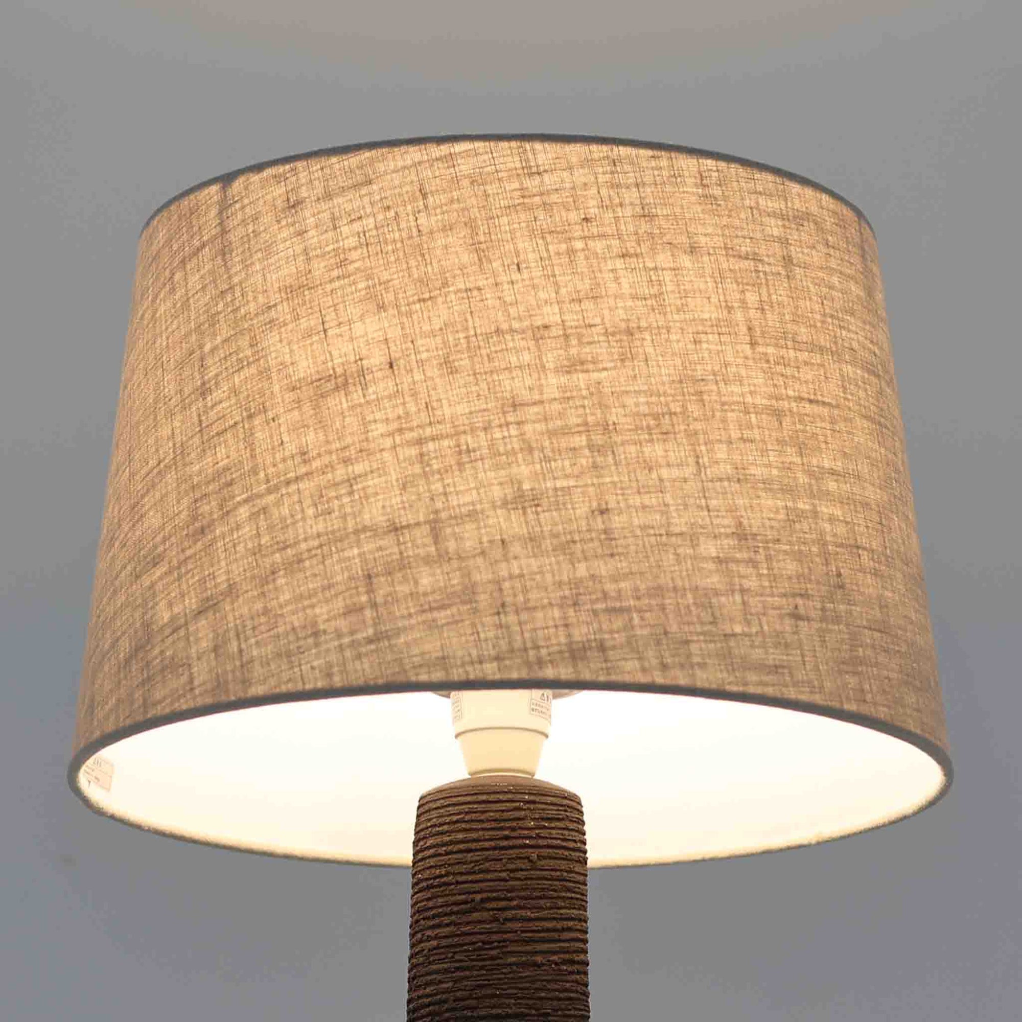 Soholm Keramik（スーホルム・セラミック）製による高さ95cmのビンテージランプです。ベースには緑色の釉薬で仕上げられた陶磁器が用いられ、花模様のレリーフが浮かび上がる温かみのあるデザインが魅力です。細身で長く伸びた支柱部分には素朴な質感が活かされ、上部にはシンプルなリネンシェードを合わせることで、柔らかな光を優しく拡散します。陶器製ランプとしては稀に見る大きさで、テーブルランプでありながらフロアランプのような存在感を放ち、リビングのアクセントや間接照明としても活躍します。陶芸的な味わいと経年の風合いが調和した、北欧ビンテージならではの逸品です。