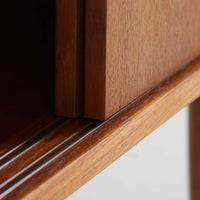 こちらの小ぶりなボードは、温かみのあるチーク材を用いたすっきりとした佇まいが魅力の北欧ビンテージ家具で、スライド扉を開くと左右に棚板付きの収納スペースが現れ、日用品や小物を効率よく整理できます。直線的な箱型の構造に、細身でテーパーの効いた脚部が軽やかな印象を添え、コンパクトながら存在感のある設計が空間に落ち着いたアクセントをもたらします。経年で深まった木肌の質感も味わい深く、リビングや玄関脇のサイド収納としても取り入れやすい一台です。