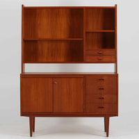 スウェーデン製のディスプレイシェルフです。チーク材の温かみある木目が美しく、上段にはオープンシェルフと小引き出し、下段には引き棚と引き戸収納と4段の引き出しが備わった実用性の高いデザインです。下段収納部には奥行きの浅い棚板が設けられており、収納する物に応じて使い分けができます。食器や本、雑貨などをすっきりと整理しながら、見せる収納としても楽しめます。扉の錠前は故障しているため施錠・開錠はできませんが、本鍵を取手として使用できるようにしています。また、扉をしっかり固定するためローラーキャッチを新たに取り付け済みです。引き出しはスムーズに開閉でき、細部まで丁寧に仕上げられています。細身のテーパー脚が全体を軽やかに見せ、経年で深みを増したチークの風合いが空間に上質な落ち着きをもたらす、北欧らしい一台です。